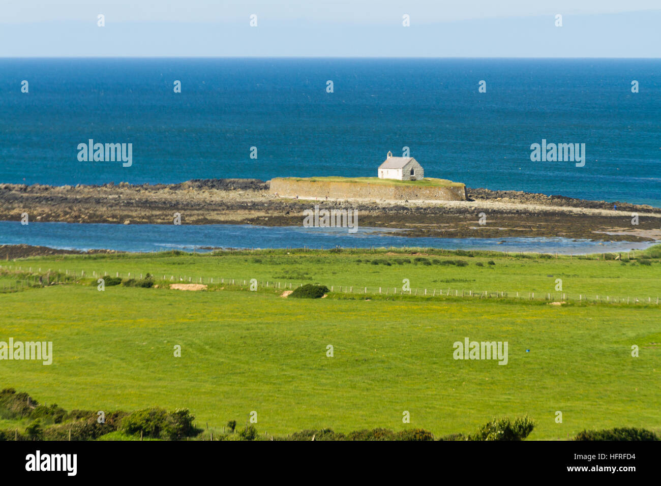 Auf der Suche, um bei Flut an St Cwyfan Kirche, die Kirche in das Meer zu sehen. Llangwyfan, Aberffraw, Anglesey, Wales, Vereinigtes Königreich, Europa Stockfoto