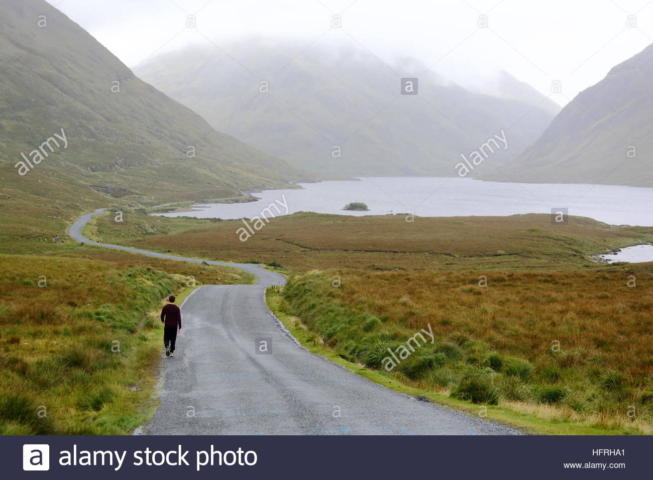 Der Weg für einen jungen Mann in einer ländlichen Landschaft im Westen von Irland Stockfoto