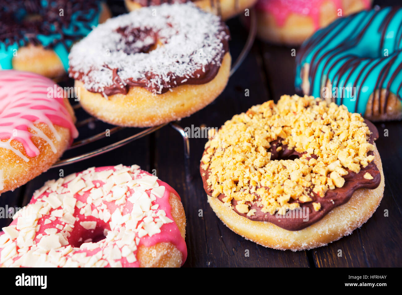 Frische hausgemachte Donuts mit verschiedenen Toppings, geringe Schärfentiefe. Stockfoto