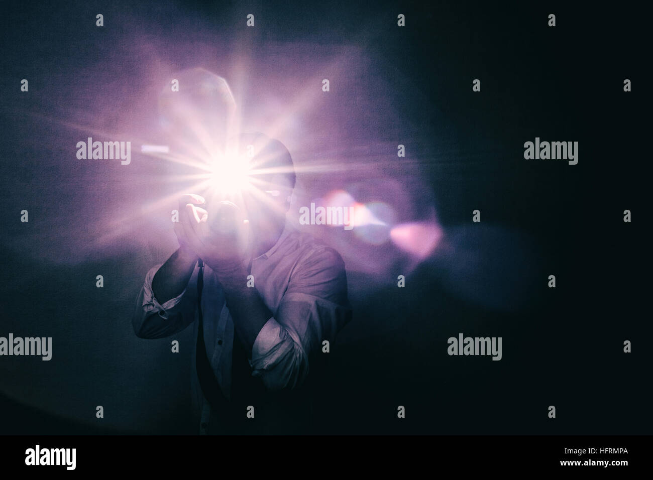 Junger Mann nimmt ein Bild auf eine Kamera mit eingebautem Blitz. Helles Licht zur Beleuchtung des Rahmens. Stockfoto