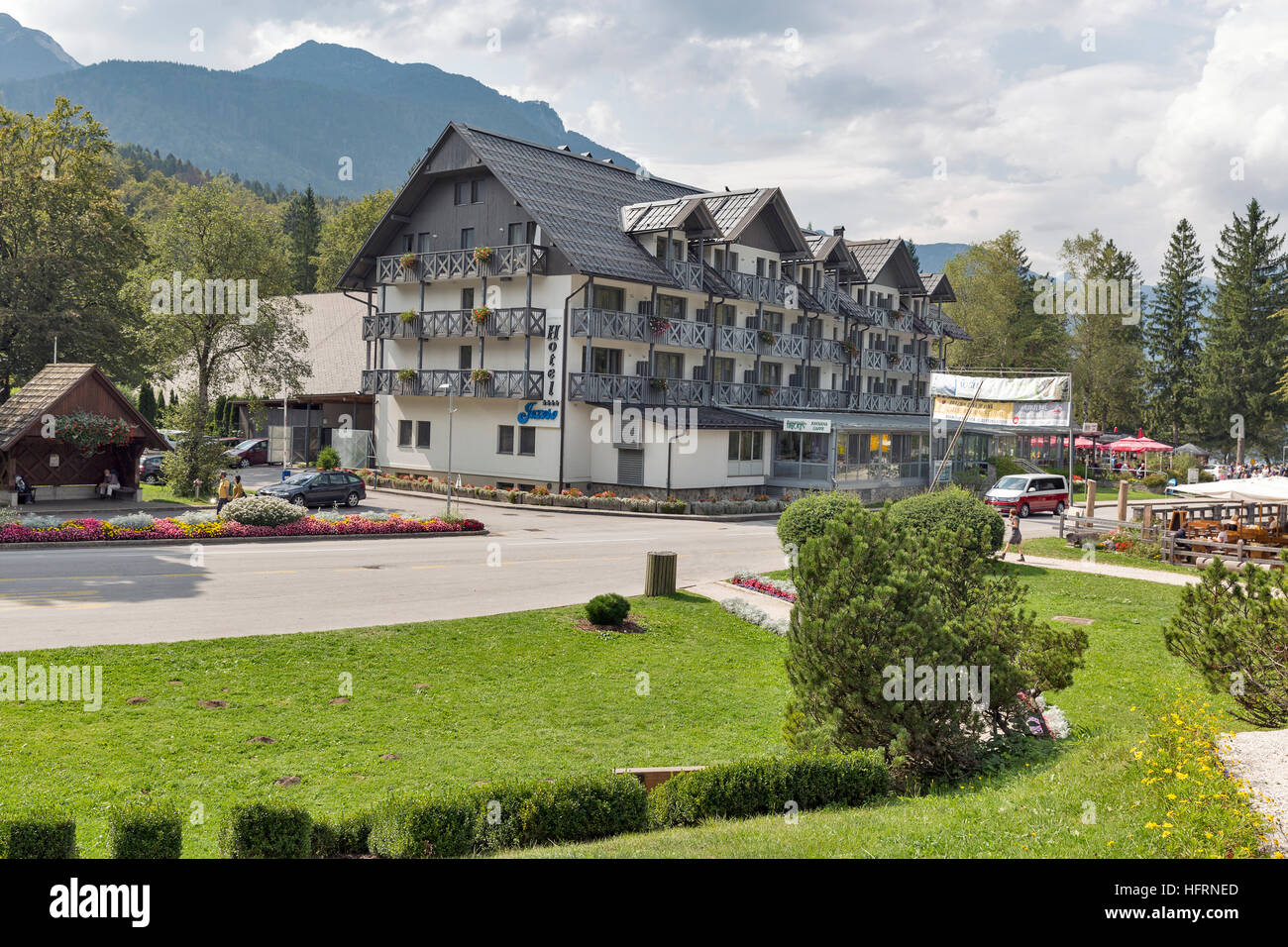 Unbekannte Menschen spazieren Hotel Jezero. Ribcev Laz ist eine Siedlung am See von Bohinj, Slowenien. Stockfoto