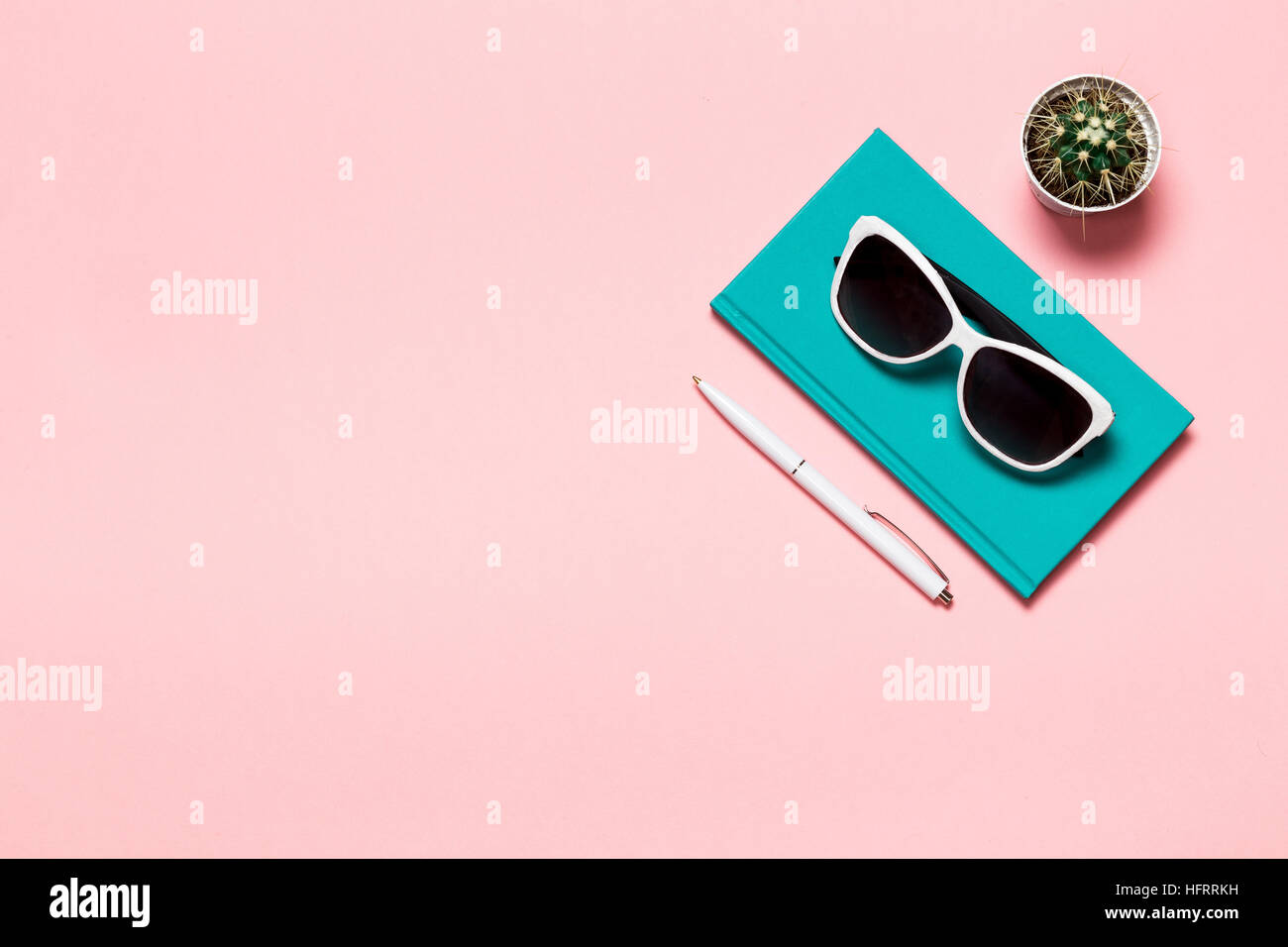 Kreative flach legen Foto des Arbeitsbereichs Schreibtisch mit Aquamarin Notebook, Brillen, Kaktus Kopie Raum rosa Hintergrund, minimalistischen Stil Stockfoto