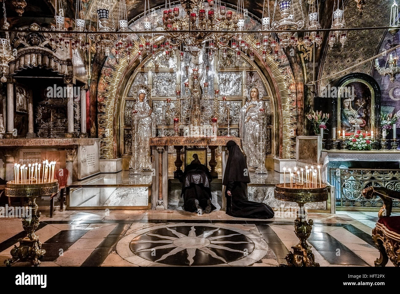 Jerusalem, Israel - 26. Dezember 2010: Zwei orthodoxe Kirche Nonnen beten auf den Knien vor dem Altar Kreuzigungen in Heilig-Grab-Kirche Stockfoto