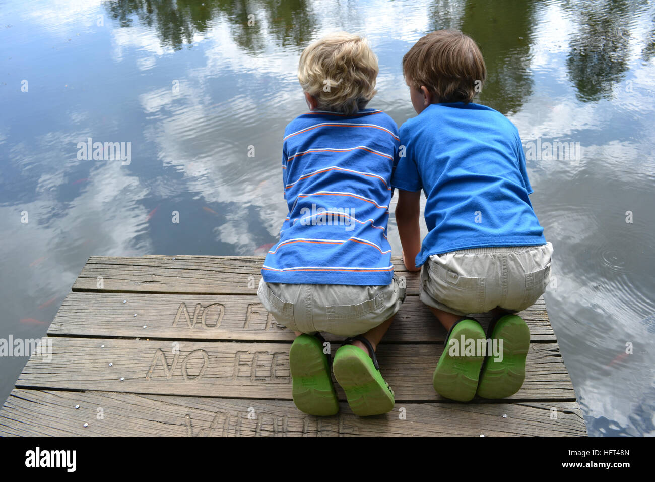 Zwei Jungs sitzen auf einem Dock Stockfoto