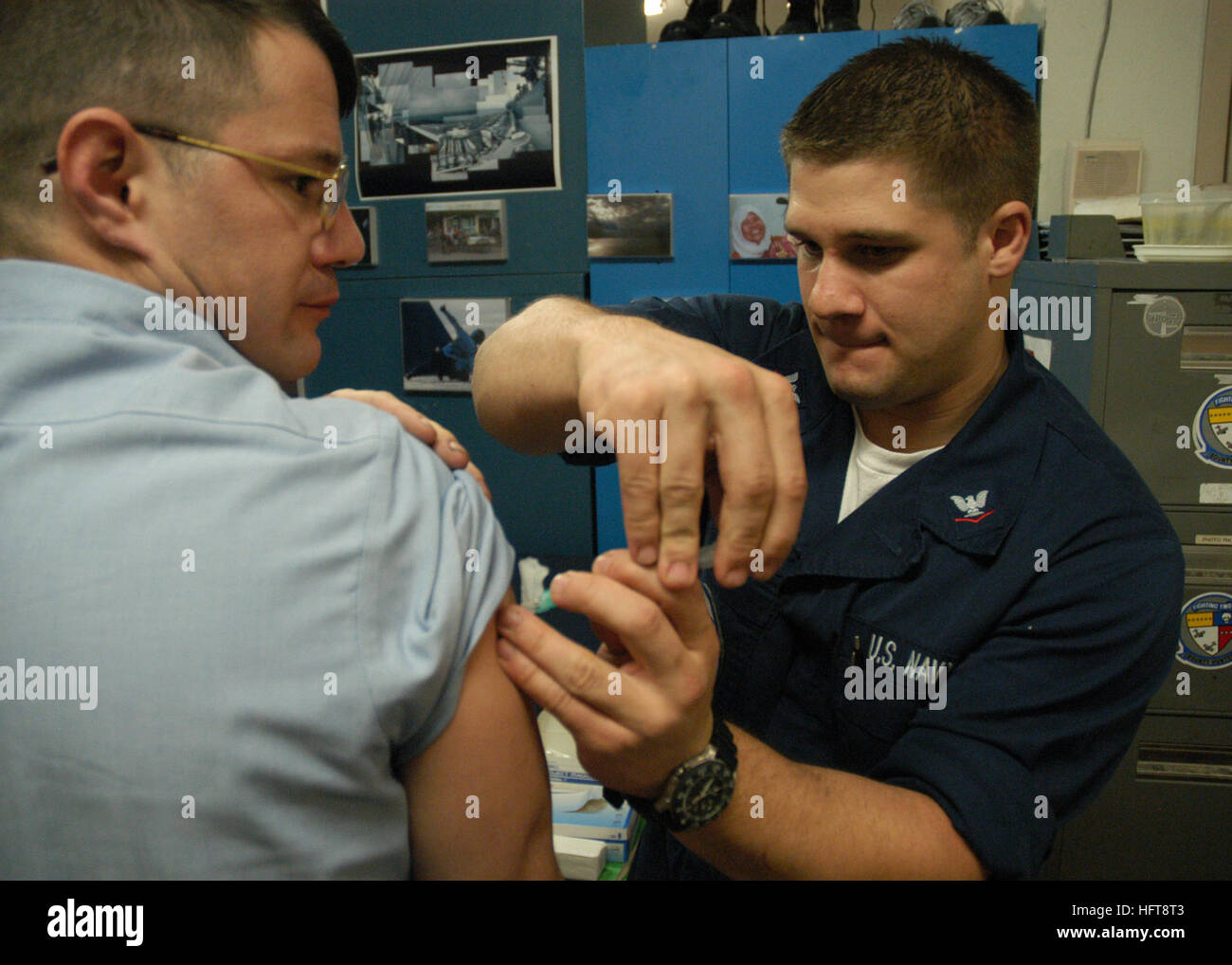 060105-N-6060O-015 Calif (5. Januar 2006)-Hospital Corpsman 3. Klasse Matthew D. Petersen Strike Fighter Squadron Two (VFA-2), verwaltet eine halbjährliche Typhus-Impfung Aviation Maschinist Mate 2. Klasse Jeffrey M. Tolbert in Vorbereitung auf die vierteljährlichen Anstieg Durchhaltefähigkeit training mit Carrier Air Wing zwei (CVW-2) an Bord der Naval Air Station Lemoore, Kalifornien begonnen.  Foto: U.S. Navy des Fotografen Mate 2. Klasse Julian T. Olivari(RELEASED) US Navy 060105-N-6060O-015 Hospital Corpsman 3. Klasse Matthew D. Petersen, zugewiesen Strike Fighter Squadron zwei (VFA-2), verwaltet eine halbjährliche Stockfoto