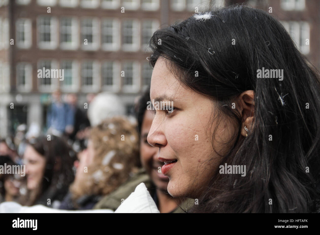 Glückliche Frau beobachtet Menschen auf Kissen Kampf Veranstaltung Stockfoto