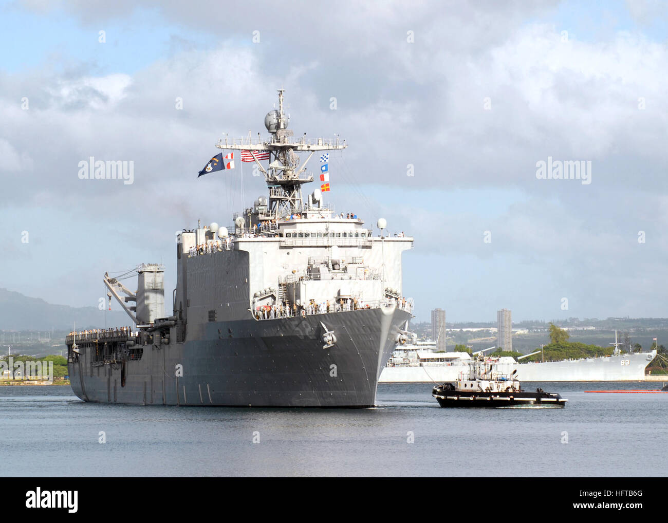 061204-N-4965F-004 Pearl Harbor, Hawaii (4. Dezember 2006) - Matrosen an Bord Dock Landungsschiff USS Pearl Harbor (LSD-52) Mann die Schienen als ein Schlepper, Naval Station Pearl Harbor zugewiesen führt das Schiff in Pearl Harbor. USS Pearl Harbor ist derzeit im Hafen um diejenigen ehren, die tapfer kämpften auf um der Insel Oahu während des Angriffs auf 7. Dezember 1941 zu verteidigen. Foto: U.S. Navy Mass Communication Specialist 1. Klasse James E. Foehl (freigegeben) US Navy 061204-N-4965F-004-Matrosen an Bord Dock Landung Schiff USS Pearl Harbor (LSD-52) Mann die Schienen als ein Schlepper, Naval Station Pearl Harbor Guid zugewiesen Stockfoto