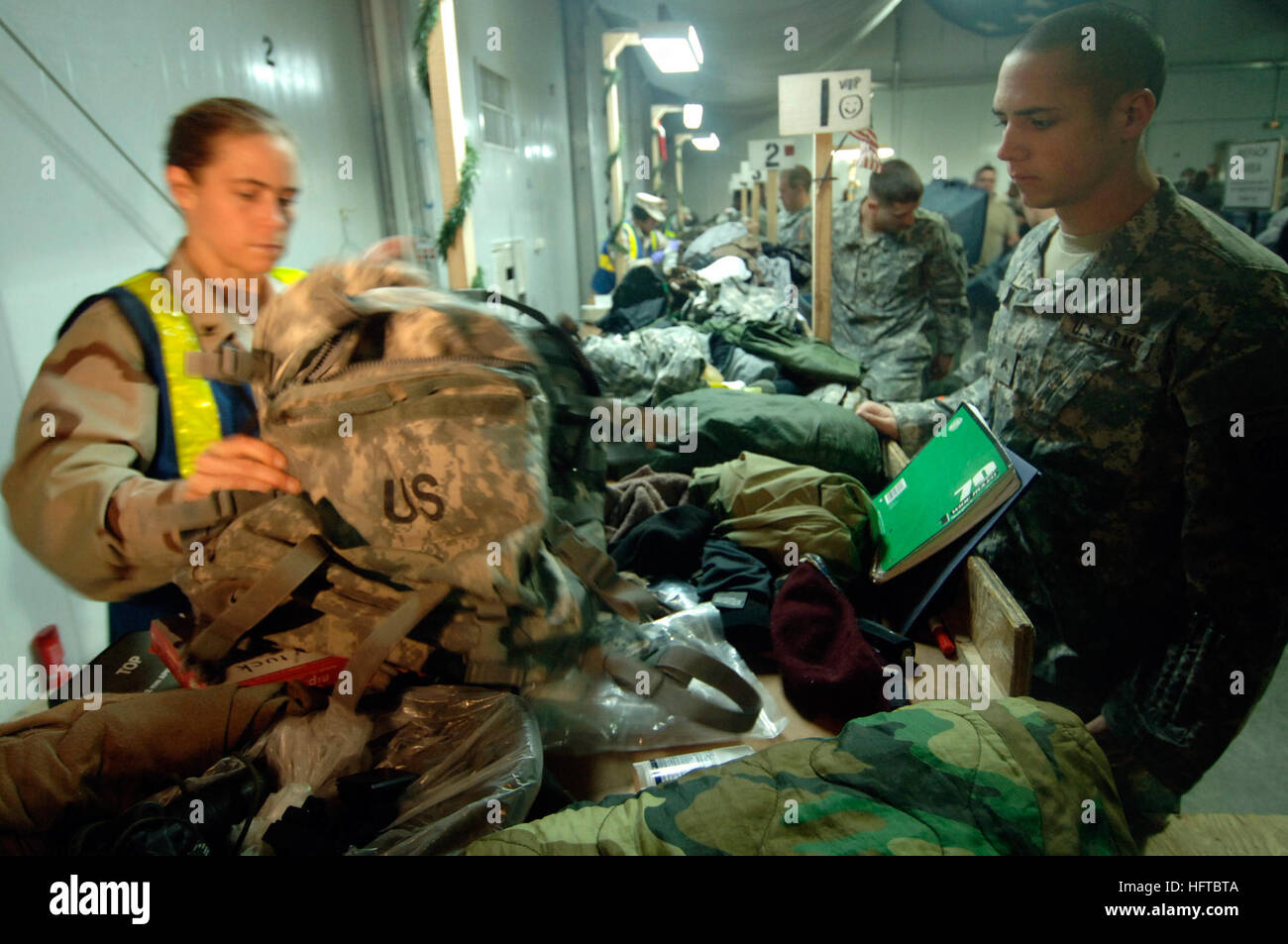 061212-N-8148A-019 Kuwait (12. Dezember 2006) - ein Soldat Armee zugewiesen 82nd Airborne Division steht und beobachtet, wie seine persönlichen Sachen gesucht und von Zoll Grenze Clearance Agent Mass Communication Specialist geprüft 3. Klasse Martha Stokes. Stokes ist ein Reservist aus Houston Reserve Center bereitgestellt und Marine Zoll Bataillon Romeo zugeordnet ist. Marine Zoll Bataillone sind mit Inspektion Elemente wie regelmäßigen persönlichen Gepäcks, Fahrzeuge und militärische Ausrüstung, die Rückkehr in die Vereinigten Staaten beauftragt. Dies sorgt dafür, dass Schädlinge, ausländische Pflanzen oder Schmuggelware Gegenstände nicht eingeben die Stockfoto