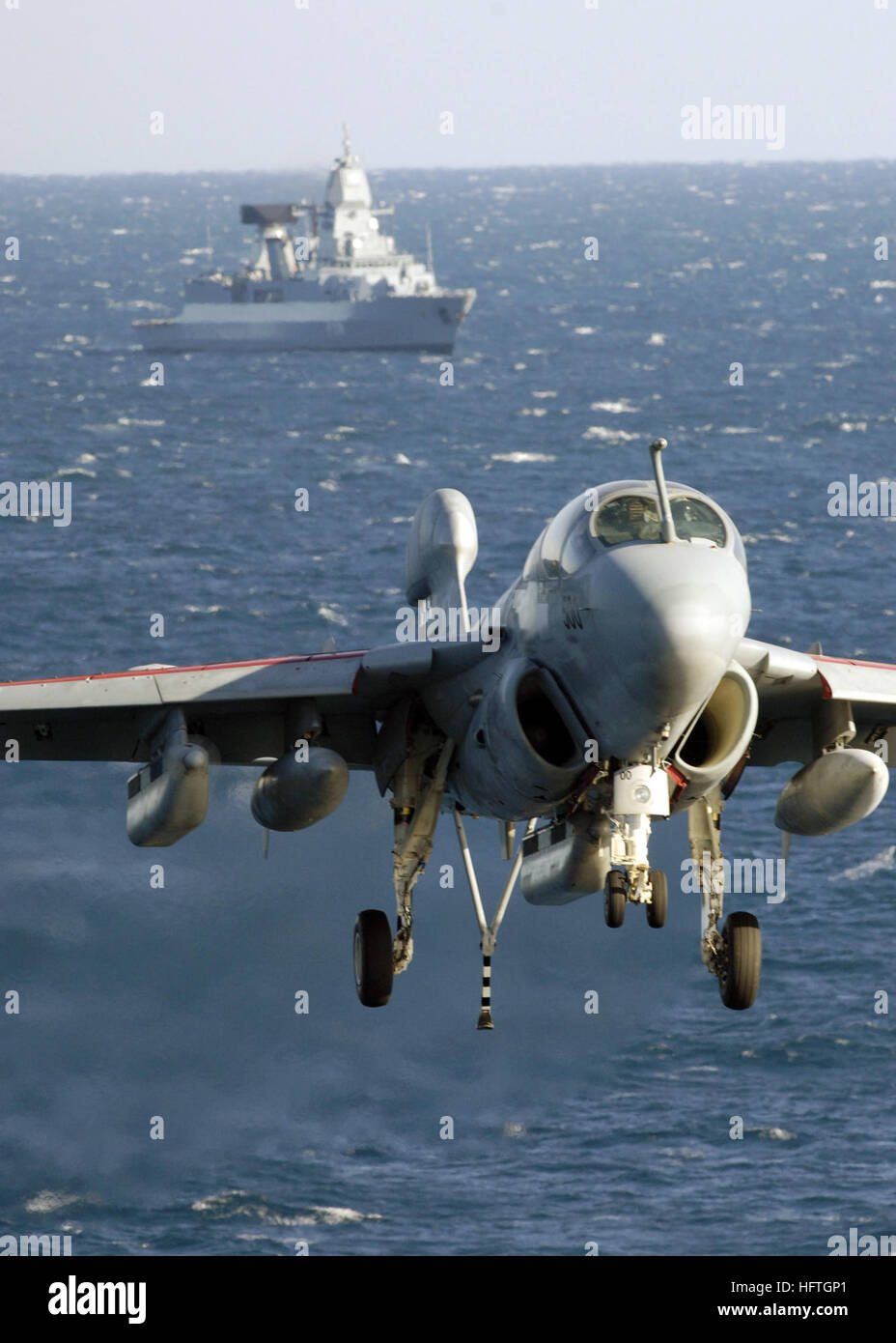 070304-N-9742R-002-Atlantik (4. März 2007) - eine EA-6 b Prowler, zugewiesen, die "Türme" von Electronic Attack Squadron (VAQ) 137, nähert sich der Landeplatz der nuklear angetriebene Flugzeugträger USS Enterprise (CVN-65) mit deutsche Fregatte FGS Sachsen (F219) im Hintergrund. Unternehmen führt derzeit Träger Qualifikationen im Atlantischen Ozean. Foto: U.S. Navy Mass Communication Specialist 2. Klasse Milosz Reterski (freigegeben) US Navy 070304-N-9742R-002 eine EA-6 b Prowler, zugewiesen, um die Stockfoto