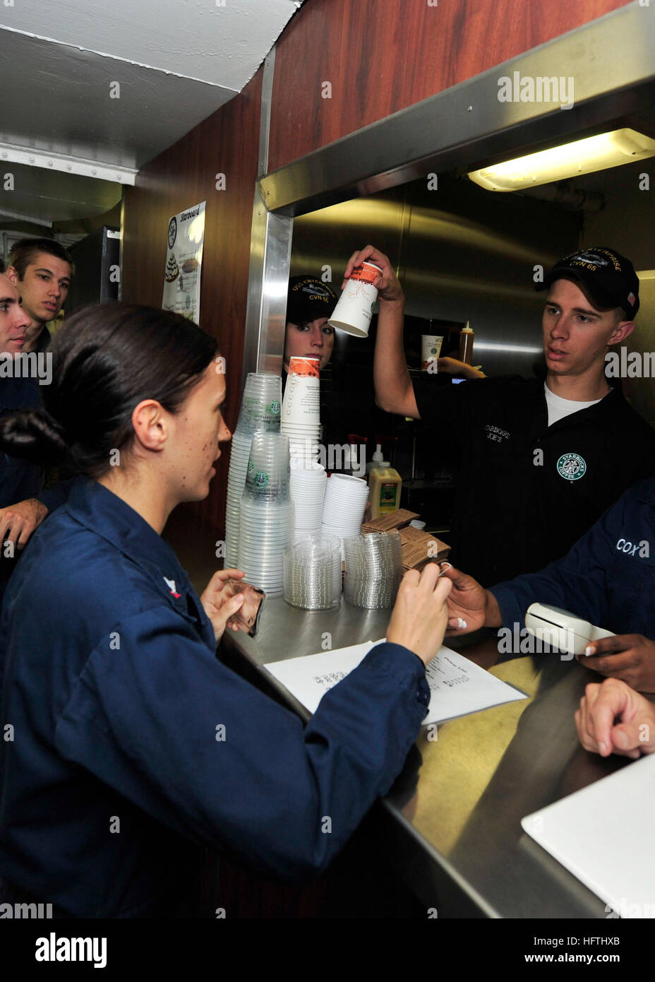101006-N-0569-K-001 Atlantik (6. Oktober 2010) BoatswainÕs Mate 3. Klasse Maeghan A. Antunes bestellt eine Tasse Kaffee aus der neu eröffneten Steuerbord Joes Café an Bord des Flugzeugträgers USS Enterprise (CVN-65). Enterprise ist die fünfte Flugzeugträger zu einen Kaffee-Kiosk geöffnet. Das Unternehmen Carrier Strike Group ist eine zusammengesetzte Einheit Übung in Vorbereitung auf eine bevorstehende Bereitstellung durchführen. (Foto: U.S. Navy Masse Kommunikation Spezialist Seemann Jared M. King/freigegeben) US Navy 101006-N-0569-K-001 Boatswain Mate 3. Klasse Maeghan A. Antunes bestellt eine Tasse Kaffee aus der Stockfoto