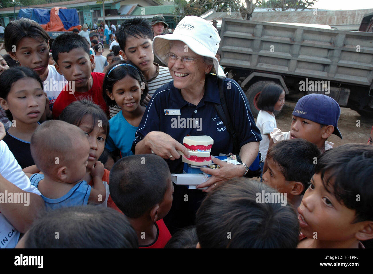 070602-N-2296G-146 ISABELA, Philippinen (2. Juni 2007) - U.S. Navy Commander Joan Cooper angebracht, um betriebliche Gesundheit Support Unit Dallas, Texas, Det. H reservieren bekommt einen Felsen Sterne Gruß von den Kindern von Isabela City, die wollen ihre große Zahnbürste zu sehen, wie sie guten Mundhygiene zeigt. Cooper ist ein Teil von einem gemeinsamen Philippines-United Staaten medizinische Civic Aktion Projekt (MEDCAP). Ihre Aufgabe ist es, Kinder auf angemessene medizinische Betreuung während der Zusammenarbeit flott Bereitschaft und Training (CARAT) Übung-Serie mit ihren philippinischen Kollegen zu erziehen. Karat ist eine jährlich stattfindende Serie von bilateralen maritime Zug Stockfoto