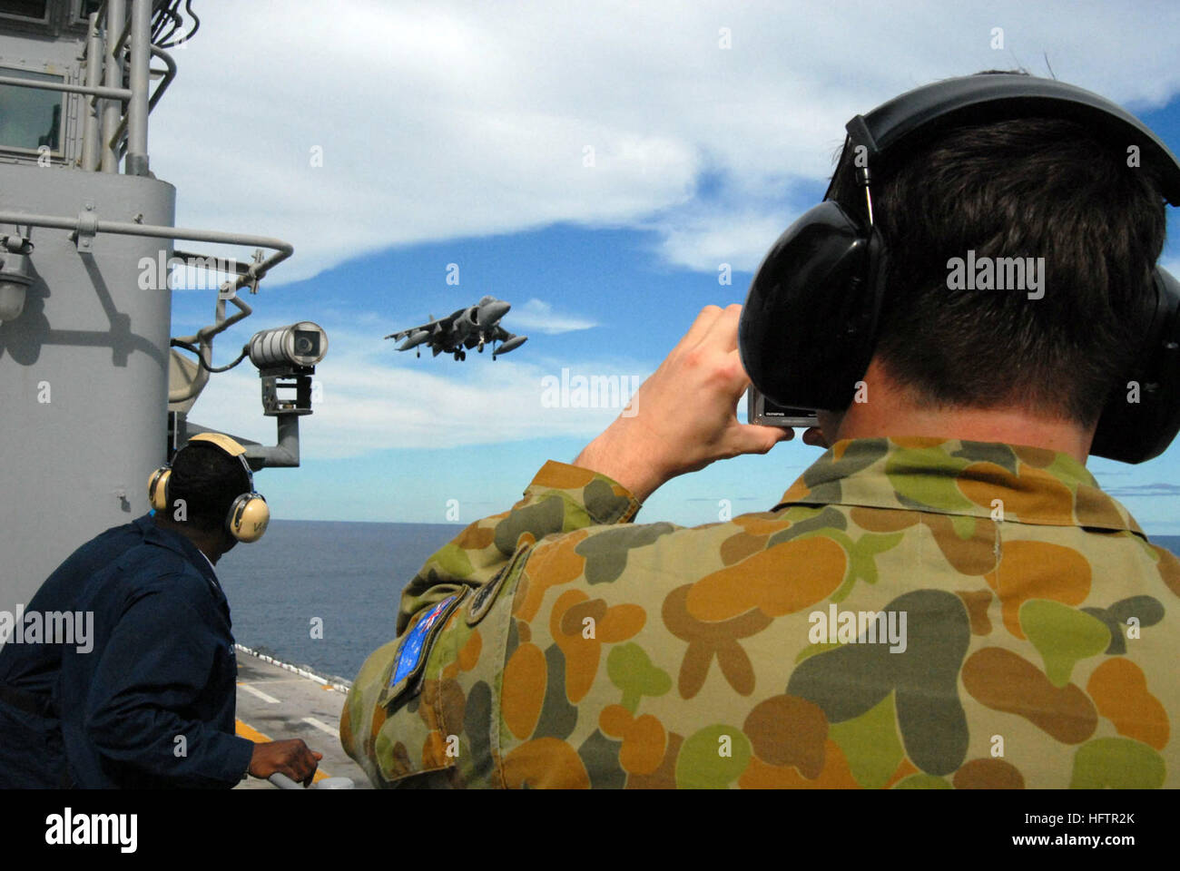 070611-N-4124C-052 PACIFIC OCEAN (11. Juni 2007) - Royal Australian Army Captain Peter Brown, Operationsoffizier für die 72. EW-Geschwader, 7. Signal Regiment nimmt einen Schnappschuss von einem AV-8 b Harrier II an Bord der USS Essex (LHD-2). Braun ist eine von mehreren australischen Personal sind Essex in Verbindung mit Talisman Saber 2007 (TS07) eingeschlagen. TS07 ist eine US-australischen Gelenk- und kombinierte Übung mit 32.000 militärische Mitglieder beider Nationen, die Krise Aktionsplanung und Abwicklung der Kontingenz Antwort in Land-, See- und Luft-Manöver feature wird. Expeditionary Strike Group 7 / Stockfoto