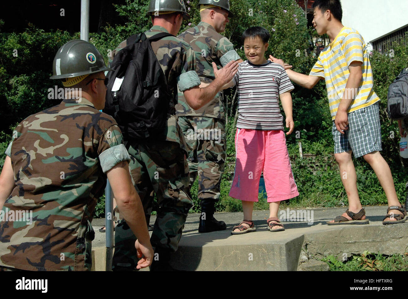 070820-N-0021M-001 GEOJEDO Insel (20. August 2007) - Seabees von Naval Mobile Bau-Bataillon 7 Detail Chinhae, Gridley in Gulfport, Mississippi, erhalten ein Willkommen an Bord von Studenten in Aikwangon Residenz für geistig und körperlich Behinderte. NMCB-7 gedreht 5.000 Protokolle, um die Luftzirkulation für Pilze ernten und ausgeräumt und abtransportiert eine weitere 5.000 vom letzten YearÕs Ernte. Die Pilze sind eine Quelle von Einkommen für Aikwangon, und sie verwenden das Geld für Reparaturen und Wartungsarbeiten an der Anlage. Die Seabees arbeitete Aikwangon während des Koreakrieges in allererster Beitrag gewesen Stockfoto