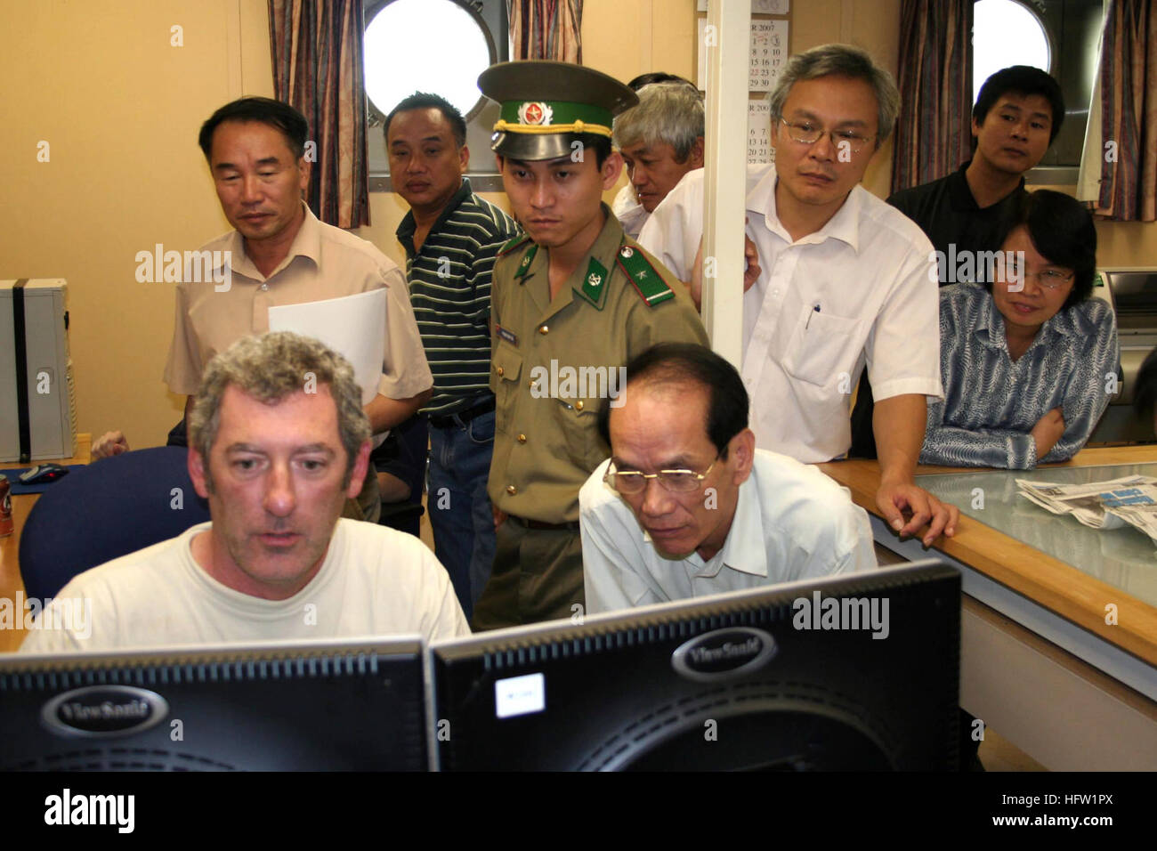 071019-N-3392B-002 DA NANG, Vietnam (19. Oktober 2007) Ð Mr Neil Duffin, sitzt links vor Computer-Monitor, ein Gutachter aus dem Naval Oceanographic Office an Bord USNS Bruce C. Heezen, zeigt hydrographischen Daten zu Hydrographers aus dem vietnamesischen Ministerium für Naturressourcen und Umwelt, sowie das Ministerium für auswärtige Angelegenheiten und die vietnamesische Marine begann. Die Daten wurden weniger als zwei Stunden früher bei einer aktuellen Umfrage Operation unter der Leitung von einem HeezenÕs zwei eingeschifften hydrographischen Umfrage starten (HSL) Schiffe. Heezen unternimmt die erste ihrer Art technische excha Stockfoto