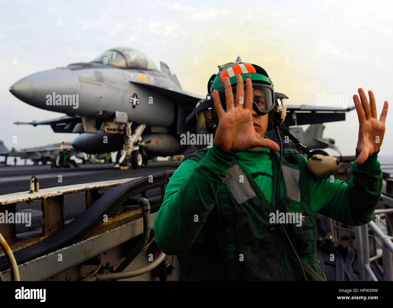 071123-N-6524M-004 Persischer Golf (23. November 2007) Deck Rand Bediener signalisiert seine Hände sind frei von der Start-Kontrollen vor dem Start einer F/A-18F Super Hornet, befestigt an der "Checkmates" des Strike Fighter Squadron (VFA) 221, deaktiviert das Flugdeck der nuklear angetriebene Flugzeugträger USS Enterprise (CVN-65). Enterprise und eingeschifften Carrier Air Wing (CVW) 1 werden zur Unterstützung der maritimen Sicherheit und der globale Krieg gegen den Terrorismus eingesetzt. US Navy Foto von Masse Kommunikation Spezialist Seemann Brandon Morris (freigegeben) US Navy 071123-N-6524M-004 Deck Rand Bediener signalisiert seine Stockfoto