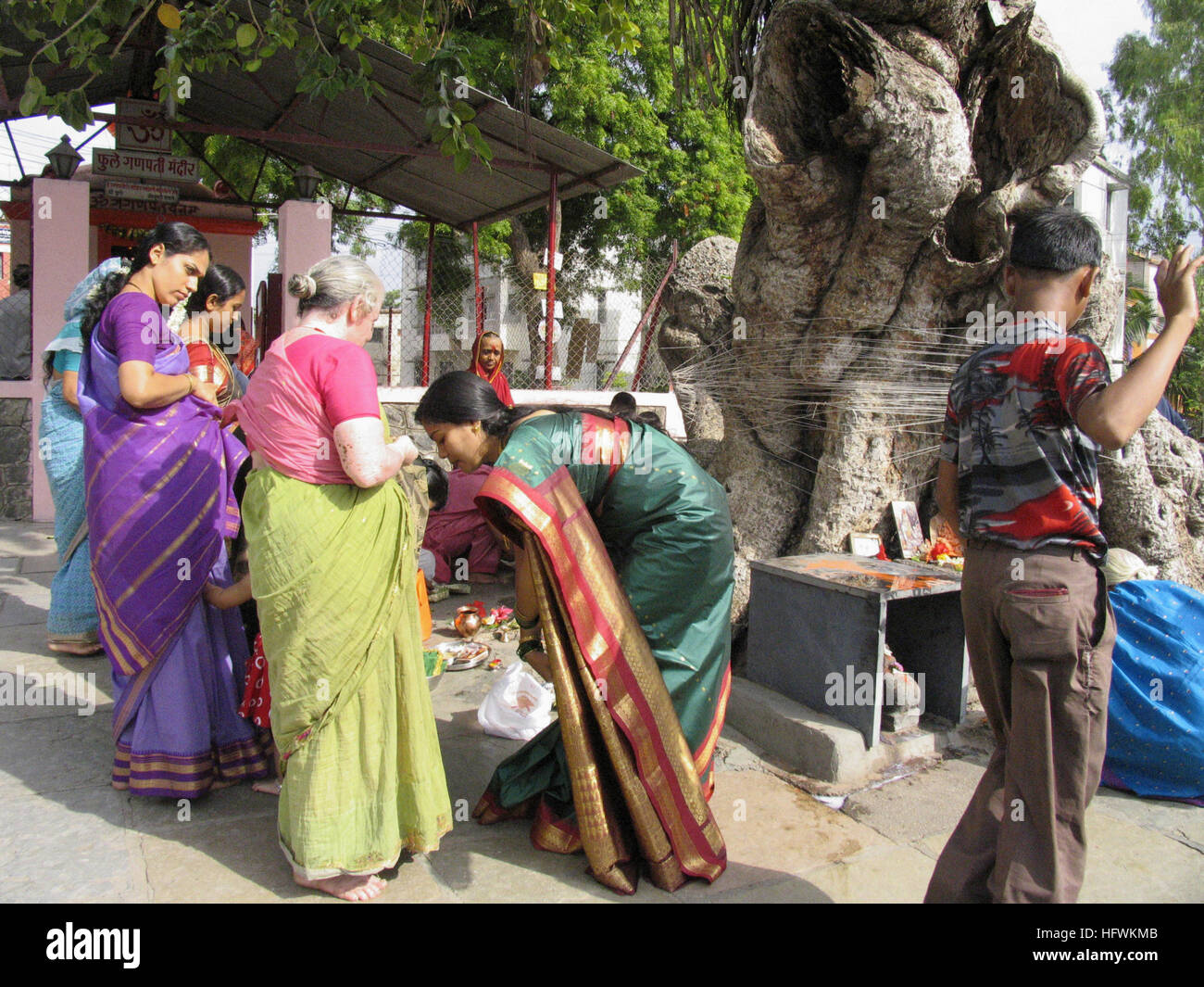 Indianerfest - MwSt Savitri: Frau binden Faden um Banyan-Baum Stockfoto