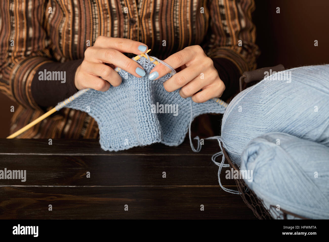 Weibliche Hände vom leichten blauen Garn stricken. Stockfoto