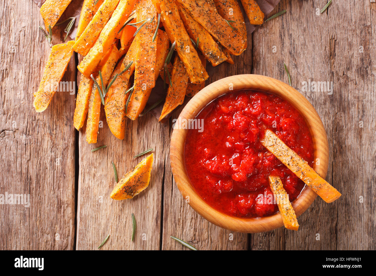 Süßkartoffel Pommes mit Rosmarin und Ketchup-close-up auf dem Tisch. horizontale Ansicht von oben Stockfoto