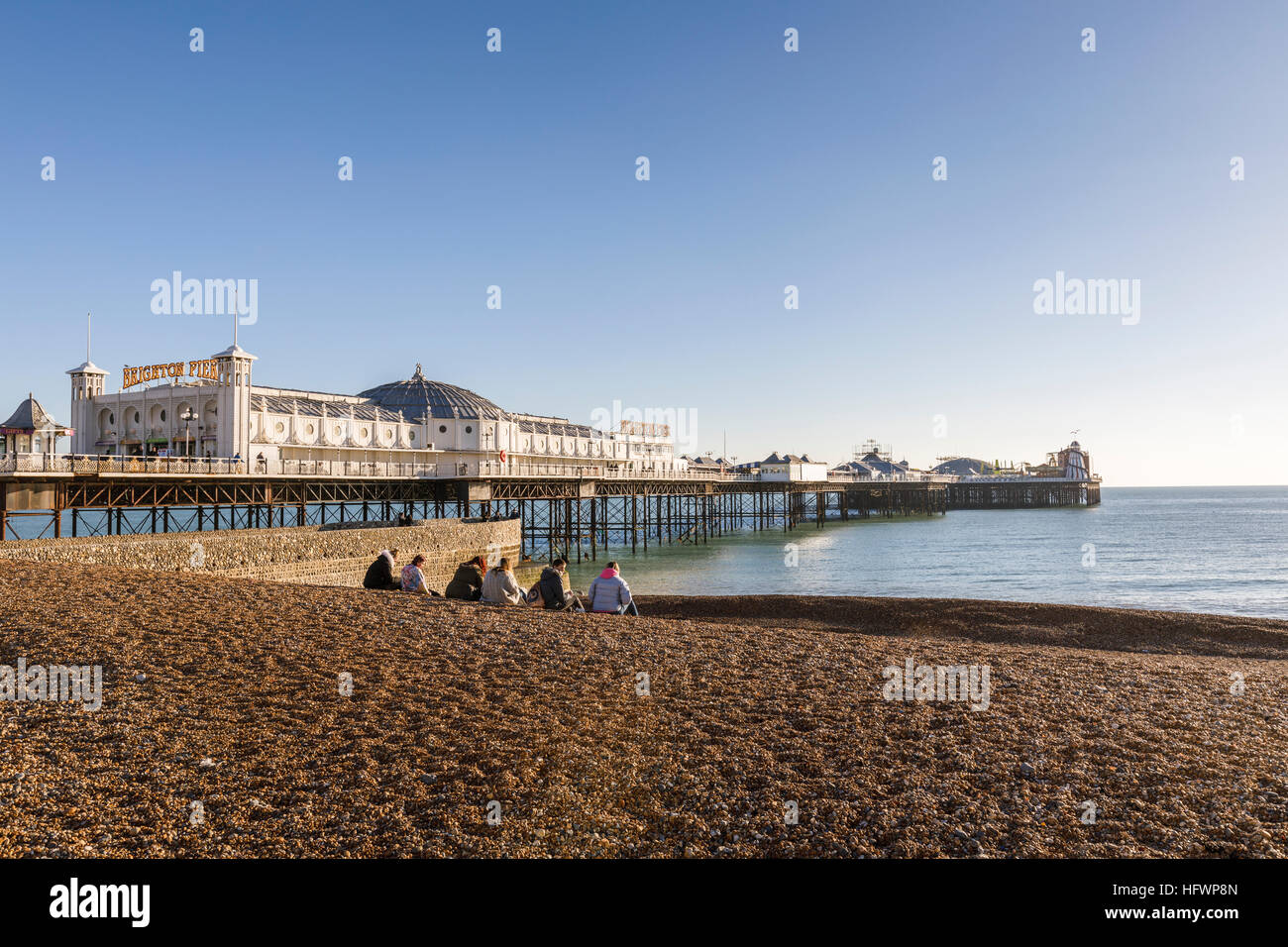 Die viktorianischen Palace Pier von Brighton und Schindel Brighton Strand mit einer kleinen Gruppe an einem sonnigen Wintertag im November mit blauem Himmel Stockfoto