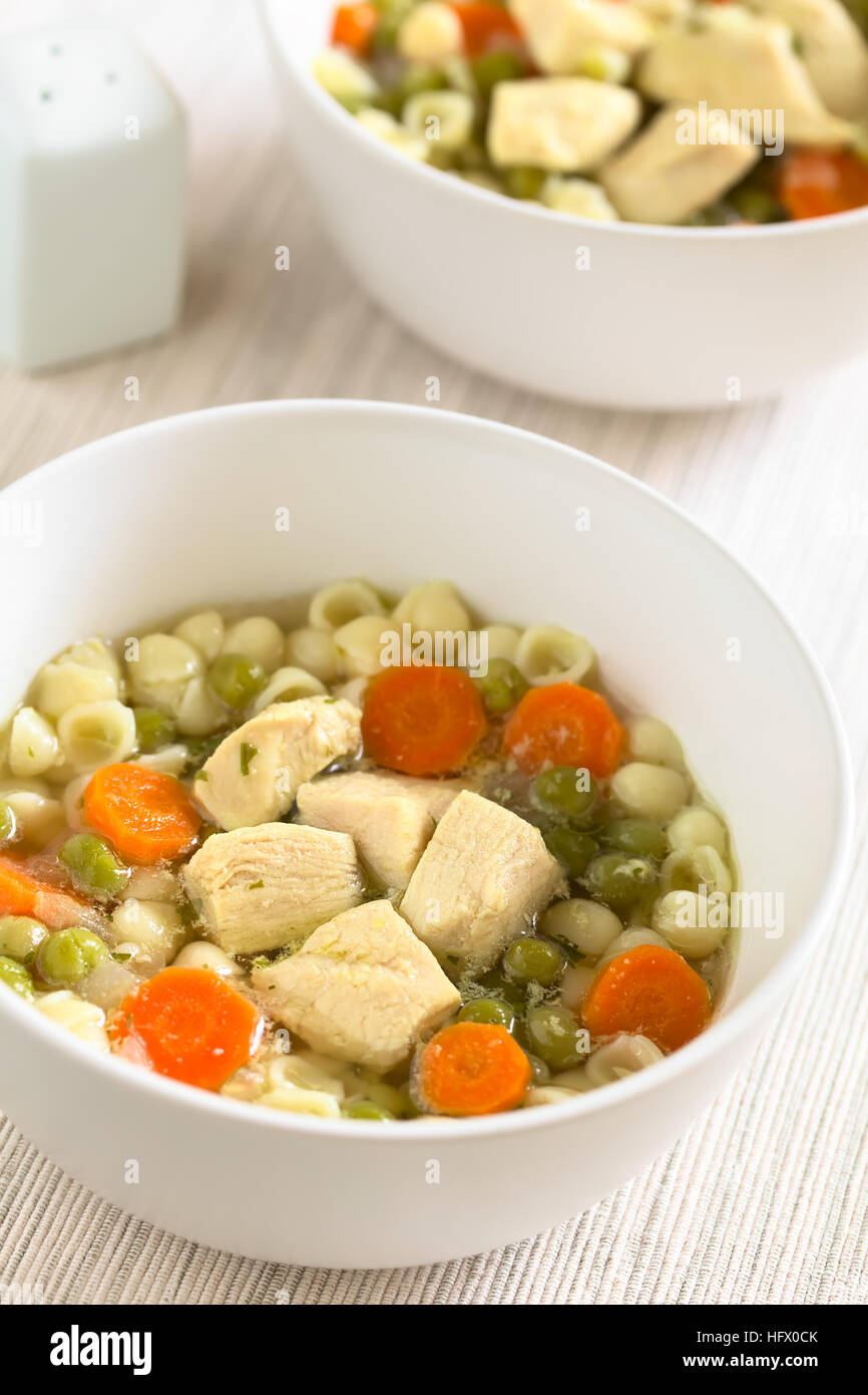 Hausgemachte Hühnersuppe mit Erbsen, Karotten und kleine Schale Nudeln ...