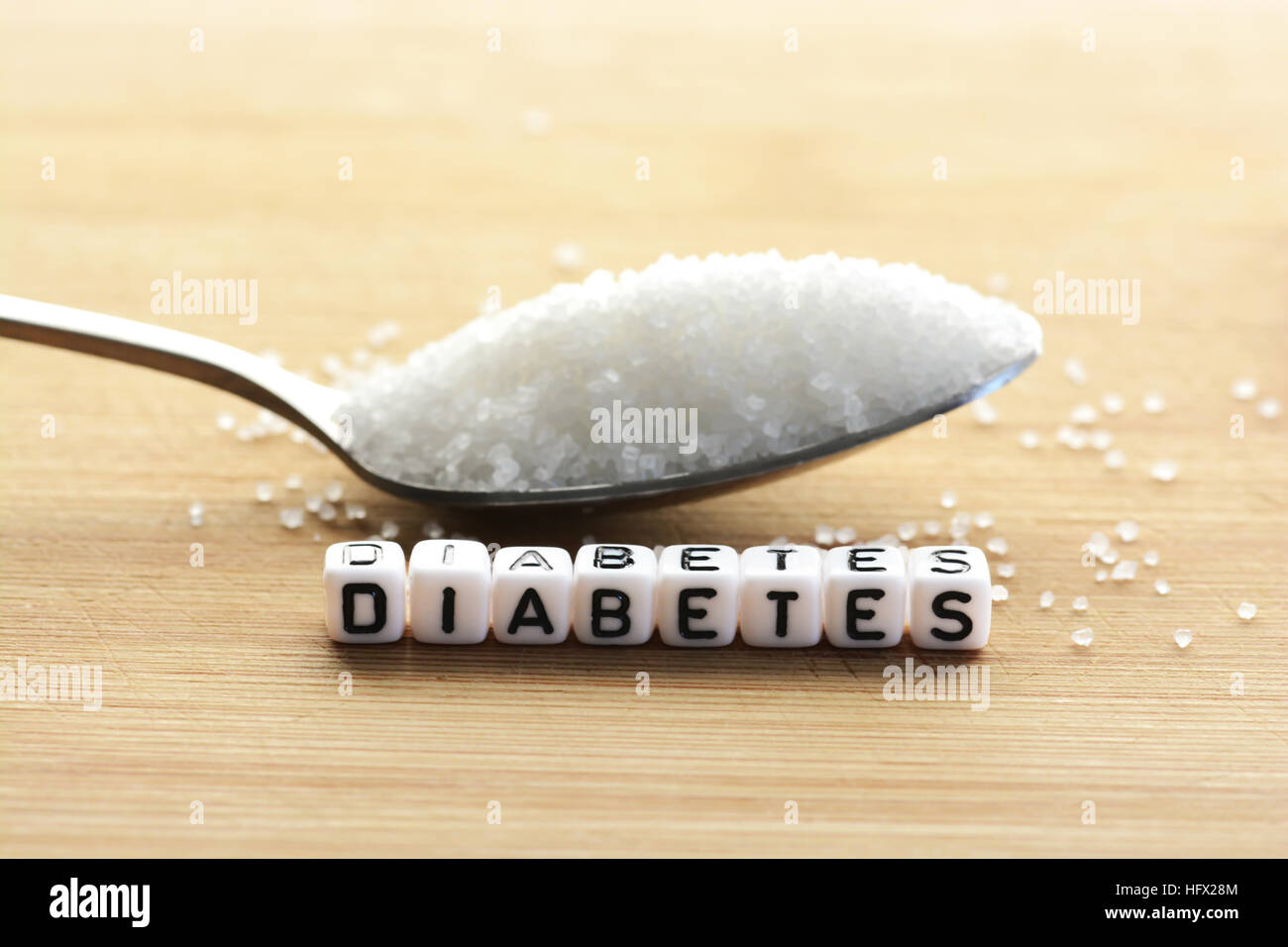 Diabetes-Blockschrift in Kreuzworträtsel und Zucker Haufen auf einem Löffel Stockfoto