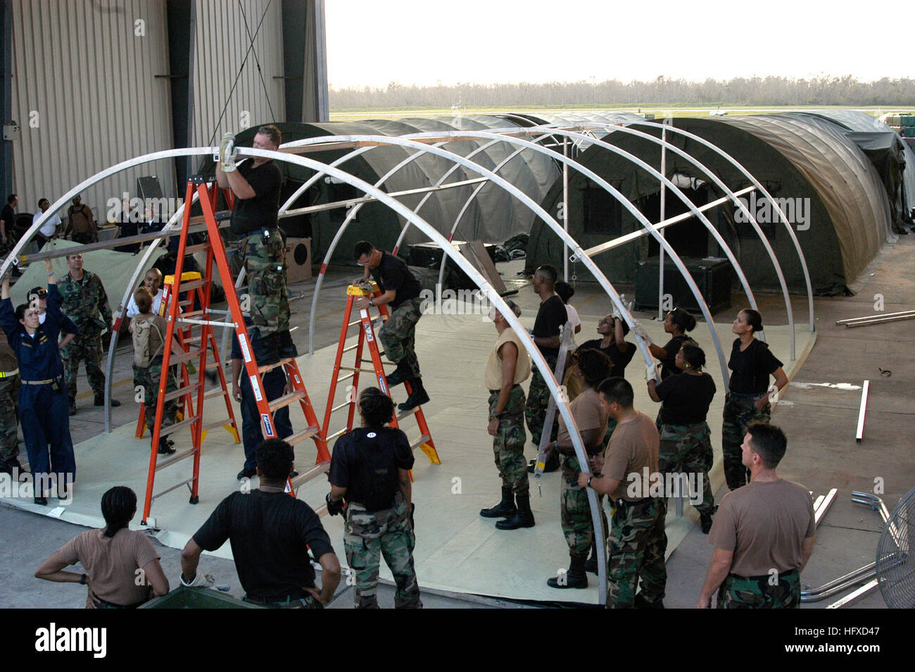 050905-N-8154G-103 New Orleans (5. September 2005) – U.S. Navy Personal zugewiesen, um Opfer zu empfangen und Behandlung Schiff Team acht (CRT-8), Sitz in Naval Hospital Jacksonville, Florida, unterstützen, Armee und Luftwaffe Reservisten wie sie ein Feldlazarett an Bord Naval Air Station Joint Reserve Base New Orleans einzurichten. Die Loslösung von Naval Hospital Jacksonville eingeschlagen auf amphibischer Angriff Schiff USS Bataan (LHD-5) zur Unterstützung bei Hurrikan Katrina Entlastung Bemühungen entlang der Golfküste der Vereinigten Staaten. Der Marine-Beteiligung an den Hurrikan Katrina-humanitäre Hilfe-Betrieb Stockfoto