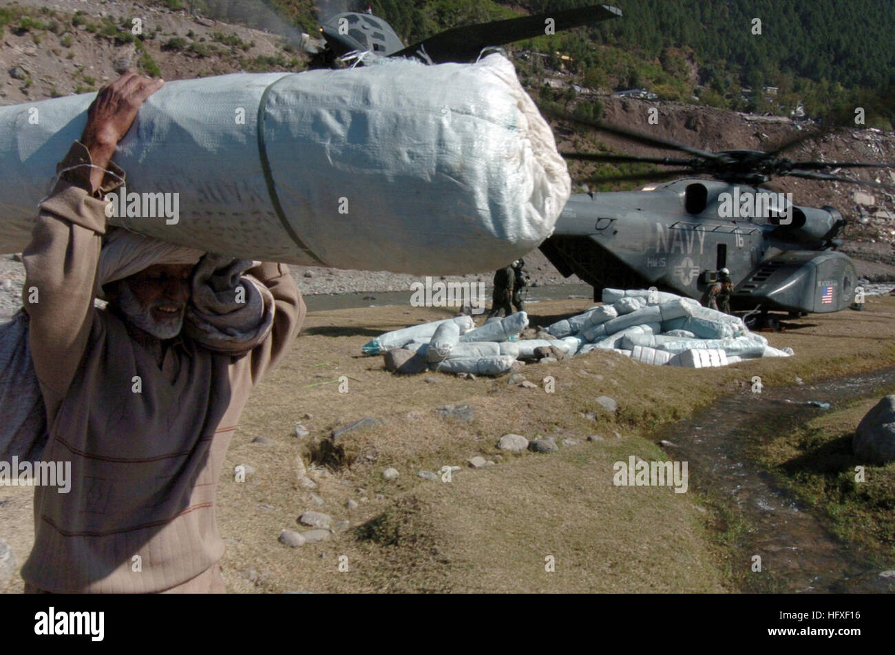 051019-N-8796S-126 Balikot Pakistan (19. Oktober 2005)---ein älterer pakistanischen Mann trägt ein Zelt von einem US-Marine MH-53 Sea Dragon vom Hubschrauber Mine Gegenmaßnahme-Geschwader 15 (HM-15). Die Regierung der Vereinigten Staaten beteiligt sich an einer multinationalen humanitäre Hilfe und Unterstützung Aufwand führen durch die pakistanische Regierung um Hilfe für die Opfer des verheerenden Erdbebens zu bringen, die die Region 8. Oktober 2005 geschlagen. US Navy Foto vom Fotografen Mate 2. Klasse (AW/SW) Timothy Smith (freigegeben) U.S. Navy 051019-N-8796S-126 eine ältere pakistanischen Mann trägt ein Zelt von einem US Marine MH-53 S Stockfoto