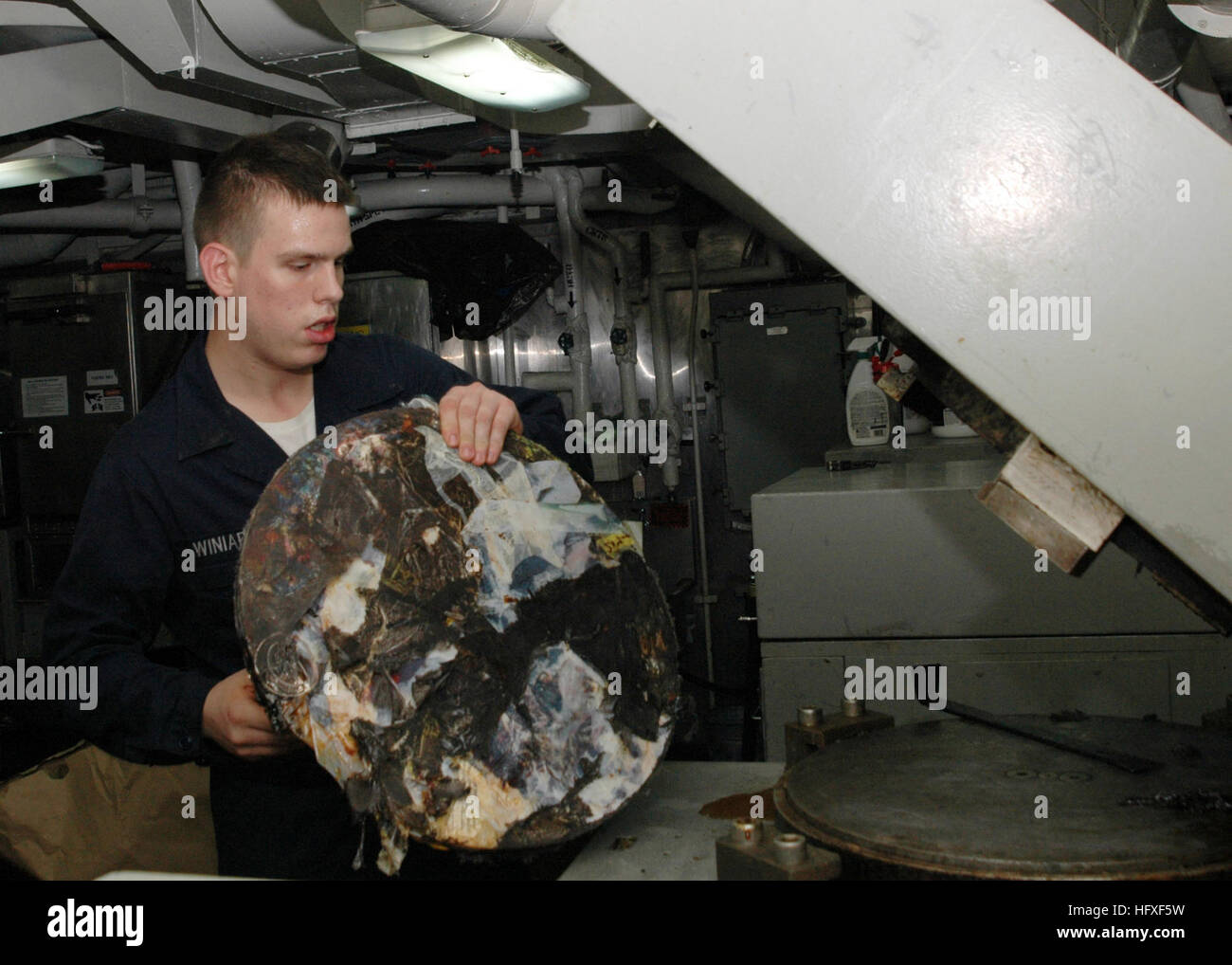 061024-N-5243R-004 Südchinesische Meer (25. Oktober 2006) - kulinarische Spezialist Seemann zugewiesen an die Versorgung an Bord der USS Essex (LHD-2) zieht eine Scheibe aus komprimierten Kunststoff aus dem Kunststoff komprimieren schmelzen Prozessoreinheit befindet sich auf dem Schiff des Kunststoff Abfälle Verarbeitung (PWP) Zimmer. Die Kunststoffscheiben gespeichert und dann vom Schiff entfernt, wenn sie in einen Hafen zur Entsorgung oder Wiederverwertung zieht. Essex ist derzeit auf die Herbst-Patrouille mit der eingeschifften 31. Marine Expeditionary Unit (MEU) und ist in den Philippinen, die Teilnahme an bilateralen Übungen, Übung Talon Vision (TV 07) und Amphibious Land Stockfoto