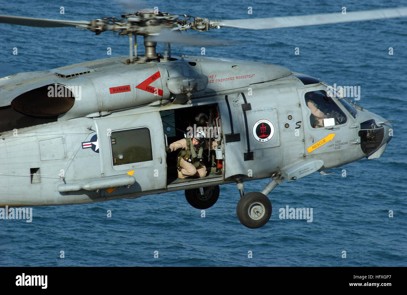 051203-N-7241L-007 3. Dezember 2005 blickt Persischen Golf an Bord USS Theodore Roosevelt (CVN-71) ein Luft-Crew-Mitglied aus der offenen Tür eines SH-60F Seahawk Hubschrauber zugewiesen, der "Dreizack" der Hubschrauber Anti-Submarine Squadron drei (HS-3) bei der Landung an Bord der USS Theodore Roosevelt (CVN-71). Nuclear powered Flugzeugträger und eingeschifften Carrier Air Wing acht laufen auf eine regelmäßige Bereitstellung Gefahrenabwehr Operationen durchführen. US Navy Foto von Fotografen Mate Airman Lehrling Nathan Laird uns Marine 051203-N-7241L-007 ein Luft-Crew-Mitglied schaut aus der o Stockfoto