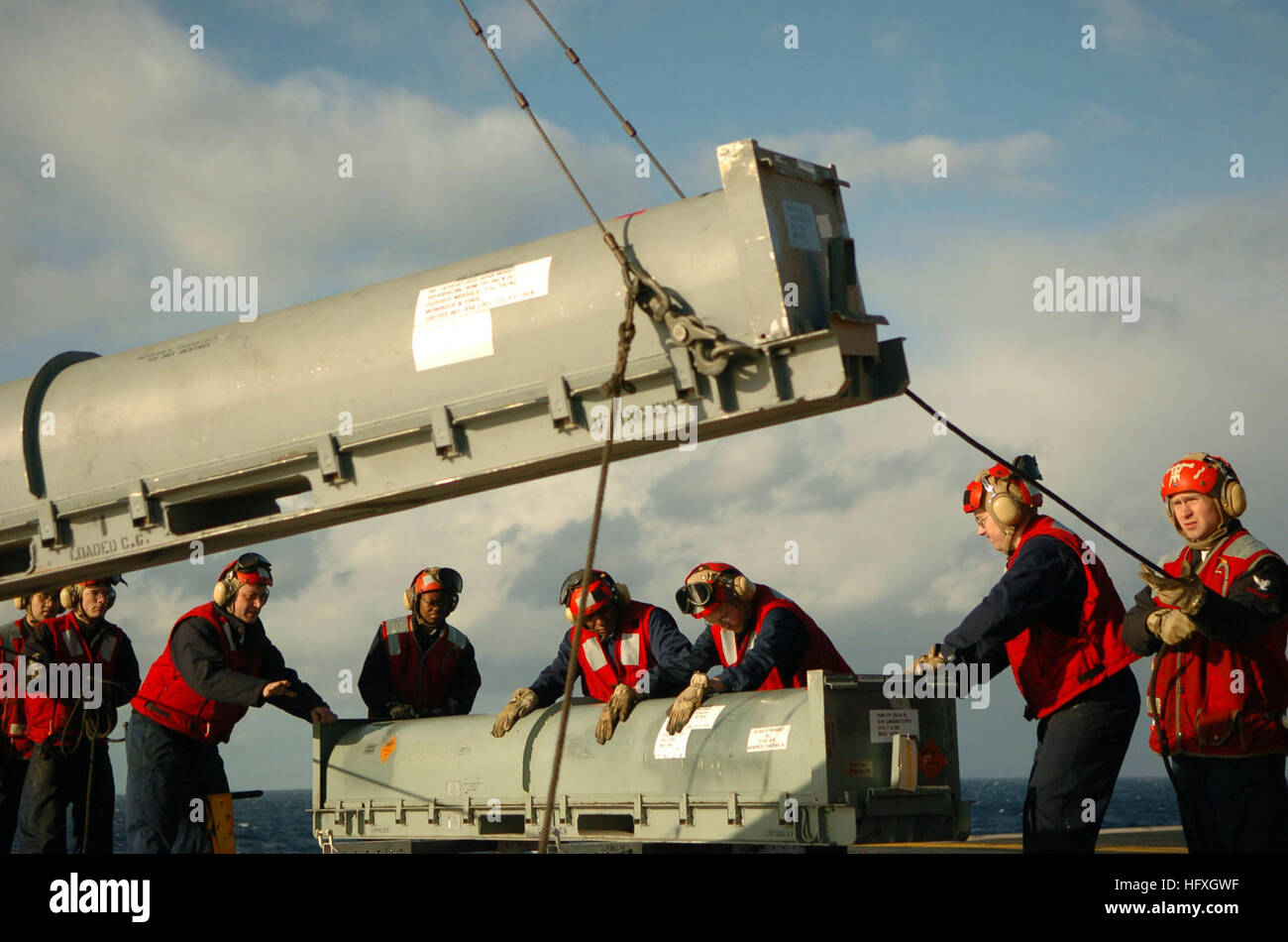 051206-N-3488C-021 South China Sea (6. Dezember 2005) - Feuer Controlmen stabilisieren einen RIM-7 NATO Sea Sparrow Missile Container, wie es auf dem Flugdeck an Bord der konventionell angetriebenen Flugzeugträger USS Kitty Hawk (CV-63) angehoben wird. Die RIM-7 Sea Sparrow ist ein mittlerer Reichweite, Krisenreaktionsmechanismus, Rakete Waffensystem, das die Fähigkeit zu zerstören feindliche Flugzeuge, Anti-Schiff-Raketen und Oberfläche Rakete Plattformen zur Verfügung stellt. Kitty Hawk und eingeschifften Carrier Air Wing Five (CVW-5) sind derzeit Durchführung von Operationen im westlichen Pazifischen Ozean. Foto: U.S. Navy PhotographerÕs Mate 3rd Class Jonathan C Stockfoto