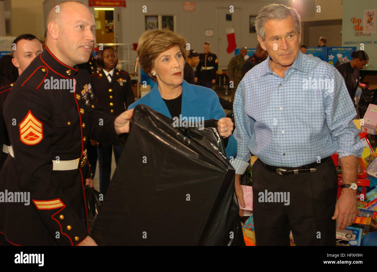 051219-N-0733J-001 Washington, D.C. (19. Dezember 2005) Ð Präsident der Vereinigten Staaten George Bush und First Lady Laura Bush Hand anlegen in der diesjährigen "Toys for Tots" Kampagne von Taschen von Geschenken an die Marine Corps Reserve Center an Bord Naval Support Facility Anacostia beladen. Das Marine Corps unterstützt Non-Profit-öffentliche Wohltätigkeitsorganisation zielt darauf ab, ein Gefühl der Anerkennung, Vertrauen und positive Erinnerungen unter der Jugend der Welt zu schaffen. Foto: U.S. Navy Journalist 2. Klasse Jake Freude (freigegeben) US Navy 051219-N-0733J-001-Präsident der Vereinigten Staaten, George Bush und First Lady Laura Bush verleihen ein ha Stockfoto