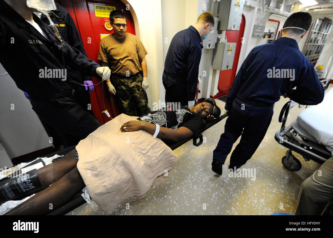 100120-N-5345W-050 BAIE DEGRAND GOAVE, Haiti (20. Januar 2010) Bahre Träger auf dem Multi-Purpose amphibischer Angriff Schiff USS Bataan (LHD-5) übertragen eine verletzte haitianische Frau von wichtigsten Triage auf der Intensivstation nach medizinischem Personal verwaltet Primärversorgung und bewertet den Umfang ihrer Verletzungen. Die Frau war einer der 19 Haitianer an Bord Bataan während eine Masse medizinische Evakuierung aus verschiedenen Bereichen rund um Port-au-Prince gebracht. Bataan, amphibische Dockingstation, Landung-Schiffe, die USS Fort McHenry (LSD-43), USS Gunston Hall (LSD-44) und USS Carter Hall (LSD 50) Op beteiligt sind Stockfoto