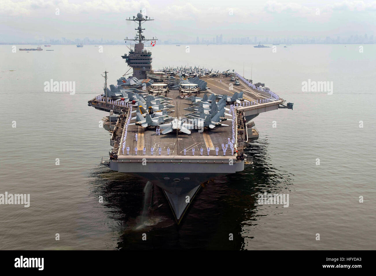 Matrosen Mensch die Schienen an Bord des Flugzeugträgers USS George Washington (CVN-73), als das Schiff eines seiner 90.000-Pfund-Anker wirft vor der Abreise Bucht von Manila. George Washington angekommen in Manila Sept. 4, so dass seine dritte Freiheit Aufruf seit seiner Abreise Yokosuka, Japan, nach einer 2010 Sommer Patrouille zu portieren. George Washington, mit seiner kombinierten Besatzung von mehr als 5.000 Matrosen, kehrt nun zurück zum Meer weiterhin Sicherheit und Stabilisierungsoperationen im westlichen Pazifischen Ozean. USS George Washington DVIDS316956 Stockfoto