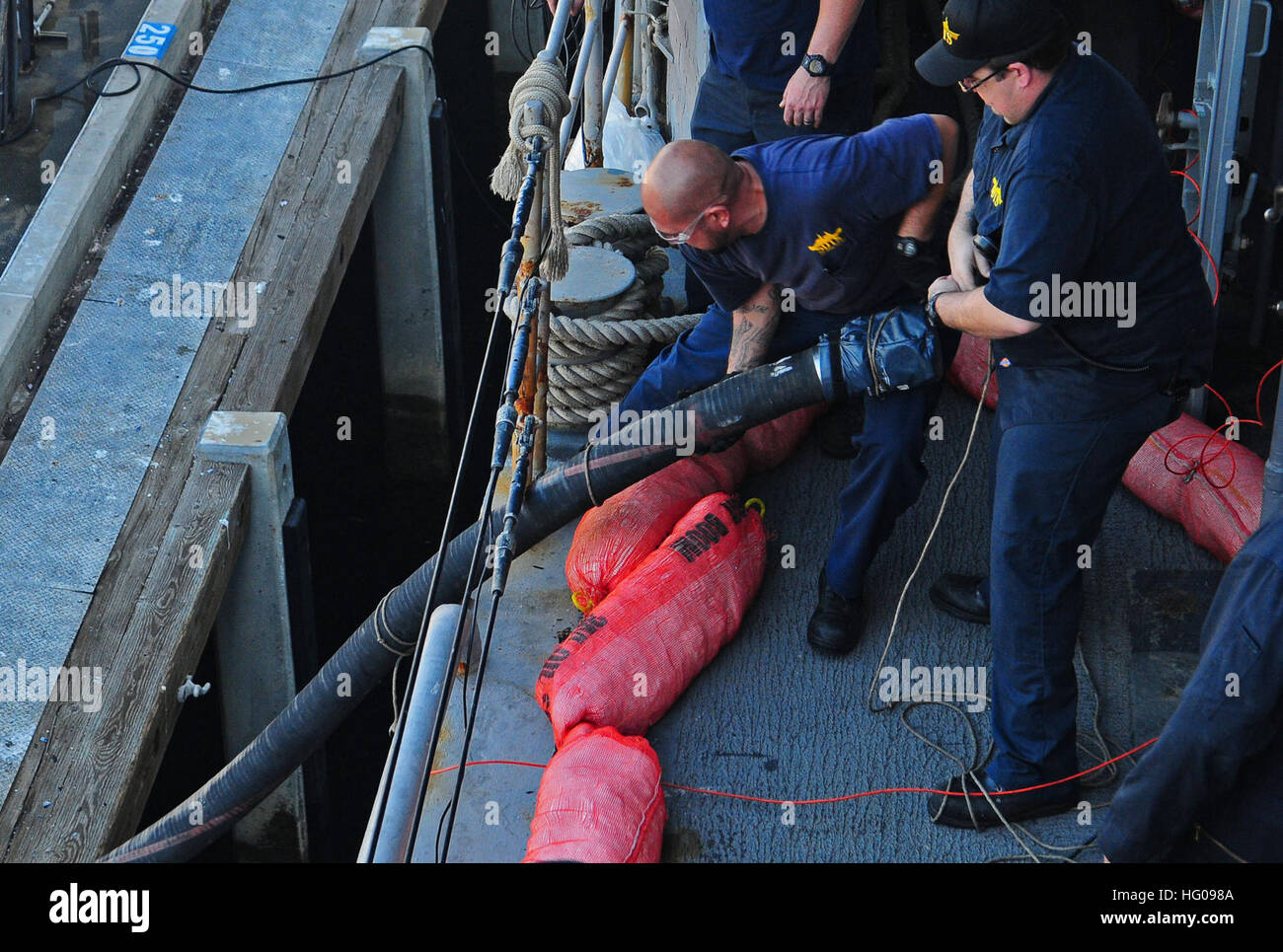 Zivilen Seeleute ziehen Kraftstoffschlauch an Bord der außer Dienst gestellten Zerstörer der Spruance-Klasse Selbstverteidigung Test Schiff USS Paul F. Foster, die an der Kraftstoff-Pier am Naval Base Point Loma vor Anker liegt. Foster, Gridley in Port Hueneme, angekommen in Point Loma, erhalten 20 tausend Gallonen von einem Biokraftstoff Diesel-Gemisch, die größte Menge, jemals verwendet werden in einem Schiff der Vereinigten Staaten. Dieses Ereignis ist eine von vielen als Bestandteil der Secretary Of The Navy Ray Mabus Plan in Richtung ein energieeffizienter Marine und das Segeln von "The Great Green Fleet" bis zum Jahr 2012 kommen. USS Paul F. Foster in Point Loma 111116-N-ZS026-099 Stockfoto