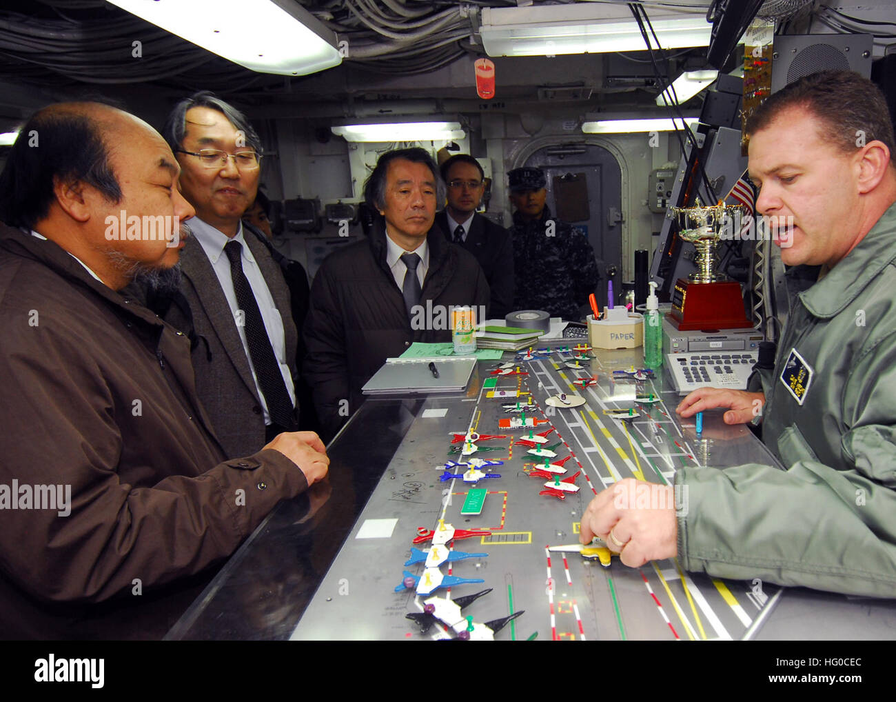 120111-N-KM939-063 YOKOSUKA, Japan (Jan. 11. 2012) Lt. CMdR Dave Hecht, Recht, Public Affairs Officer an Bord des Flugzeugträgers USS George Washington (CVN-73), Besucher aus Japan Aerospace Exploration Agency zeigt das Schiff Ouija-Brett in Flight-Deck-Steuerung. George Washington zurück an ihr vorwärts-operative Schnittstelle Commander, Flotte Aktivitäten, Yokosuka, November 22 nach der Navigation mehr als 50.000 Seemeilen in der gesamten westlichen Pazifischen Region Betrieb mit mehr als einem Dutzend verschiedener Nationen während einer neunwöchigen Patrouille. George Washington ist der Marine nur vorwärts entfaltet eine Stockfoto
