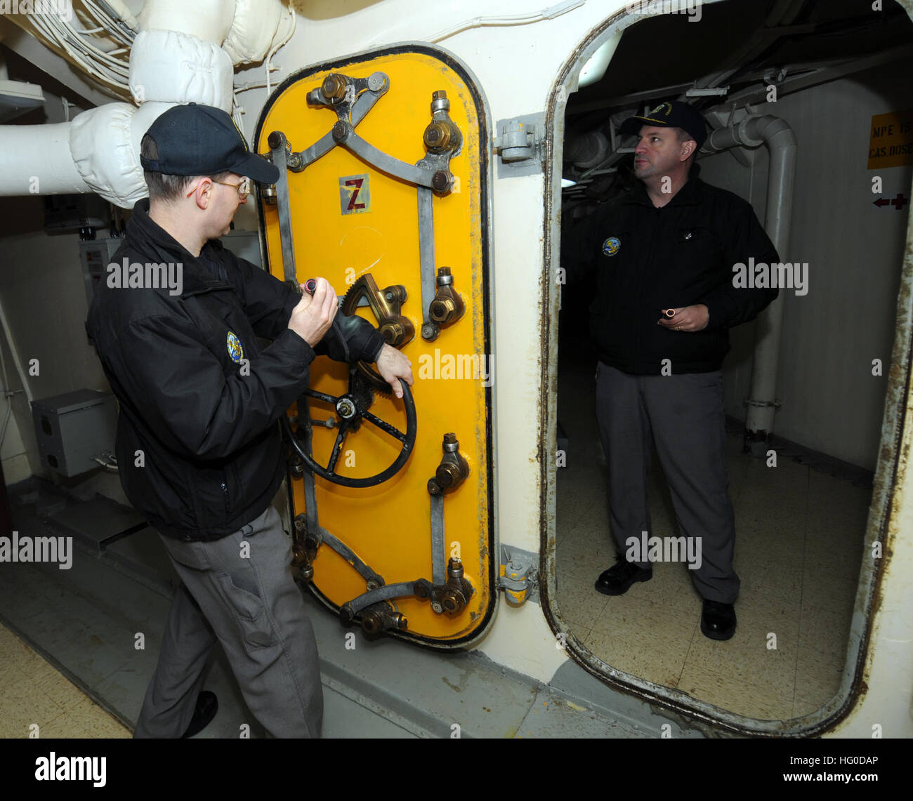 Mitglieder der Marine Board of Inspection und Umfrage (Mission) inspizieren eine gepanzerte Tür während eines Gemeindeprojektes Beziehungen an Bord der pensionierte Schlachtschiff USS Wisconsin (BB-46). Das Schiffsmuseum plant in naher Zukunft weitere Räume für die Öffentlichkeit öffnen und Mission Mitglieder freiwillig, um ihnen zu helfen, durch die Identifizierung potenzieller Sicherheitsbedenken und tragen dazu bei, eine langfristige Wartungsprogramm zu entwickeln. USS Wisconsin 012513-N-ZO696-036 Stockfoto