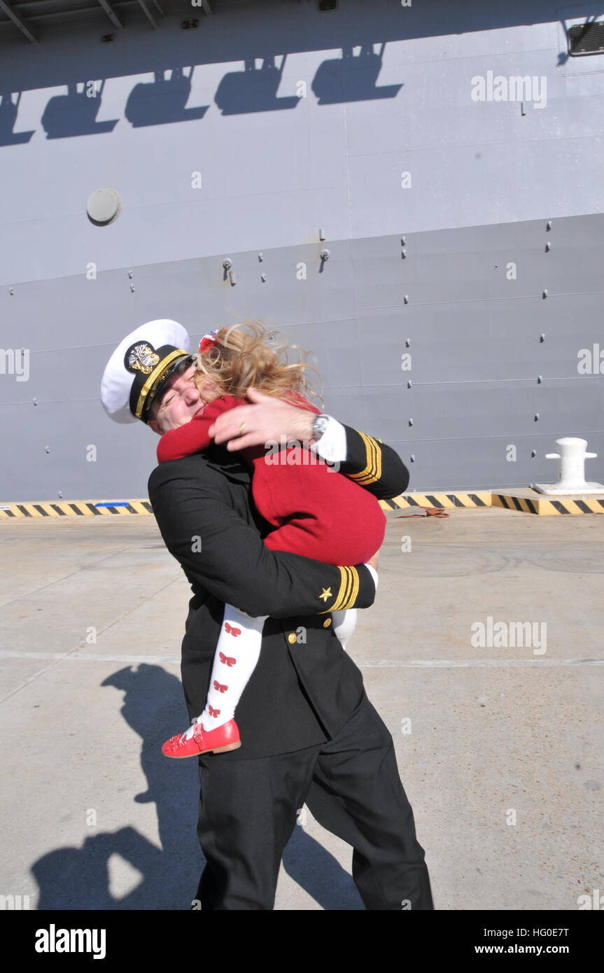 120207-N-QY430-085 NORFOLK (7. Februar 2012) Lt. CMdR Julian Carswell umarmt seine Tochter während einer Heimkehr-Feier für die amphibischen Angriff Schiff USS Bataan (LHD-5) am Naval Station Norfolk nach Abschluss eine 10 1/2-Monats-Bereitstellung zu den US-5. und 6. Flotte Bereichen Verantwortung. Die Heimkehr markiert das Ende der längsten Bereitstellung für ein Schiff der US-Marine in mehr als vierzig Jahren. Die Bataan amphibische bereit Gruppe unterstützte Operationen Enduring Freedom, Odyssey Dawn und der NATO-geführten Operation Unified Protector und Maritime Security Operations im Mittelmeerraum und in Arabien durchgeführt Stockfoto