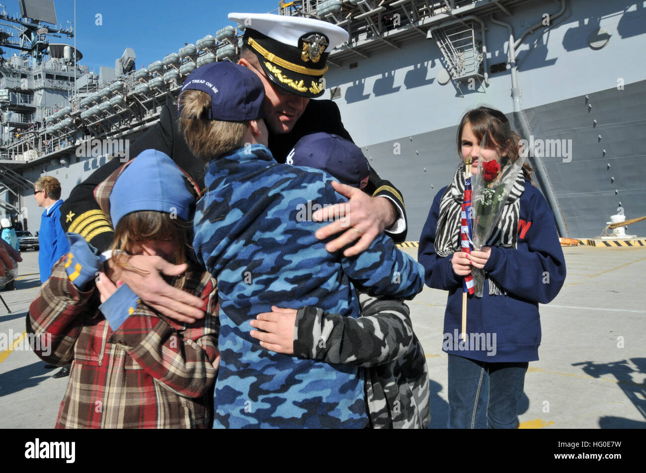 120207-N-QY430-112 NORFOLK (7. Februar 2012) Kapitän Erik Ross, Kommandierender Offizier der amphibischen Angriff Schiff USS Bataan (LHD-5), grüßt seine Familie während einer Feier der Heimkehr für Bataan am Naval Station Norfolk nach Abschluss einer 10 1/2-Monats-Bereitstellung auf die US-5. und 6. Flotte Bereiche Verantwortung. Die Heimkehr markiert das Ende der längsten Bereitstellung für ein Schiff der US-Marine in mehr als vierzig Jahren. Die Bataan amphibische bereit Gruppe unterstützte Operationen Enduring Freedom, Odyssey Dawn und der NATO-geführten Operation Unified Protector und Maritime Security Operations in der Medi durchgeführt Stockfoto