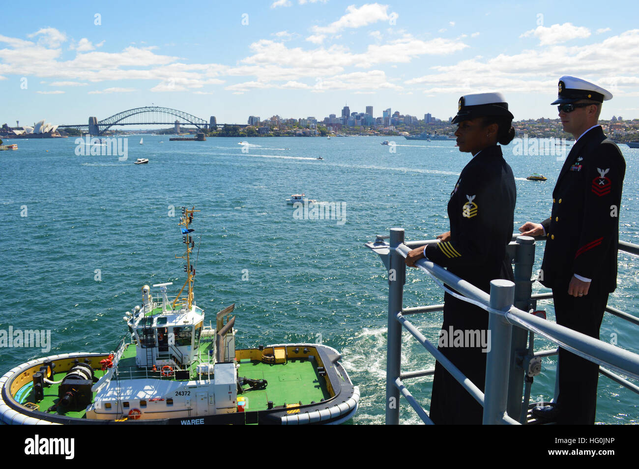 Chief Petty Officer Jazmine Farrior und Chief Petty Officer Robert Prine zugeordnet USS Chosin (CG-65) Mann die Schienen wie sie ziehen in Sydney Hafen 40 andere Kriegsschiffe und 17 historischen Großsegler als Bestandteil der International Fleet Review - der 100-Jahr-Feier von der Royal Australian Navy in Sydney teilnehmen. Streitkräfte aus fast 20 Nationen beteiligen sich an den Ereignissen die öffentlichen Schiffstouren, Flotte Parade und Feuerwerk Lichtshow umfassen wird. Chosin ist derzeit in der 7. Flotte Verantwortungsbereich, die Durchführung von Übungen, Portbesuche und Operationen Stockfoto