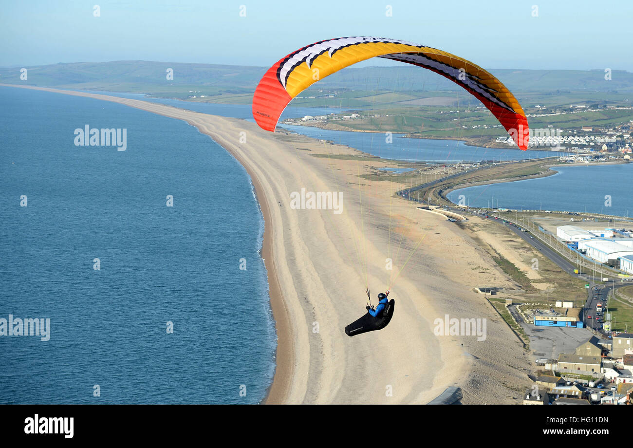Paragliding, Gleitschirm, Paragleiter, Gleitschirm, genießt das sonnige Wetter aus Chesil Beach, Portland in Dorset, England. Stockfoto