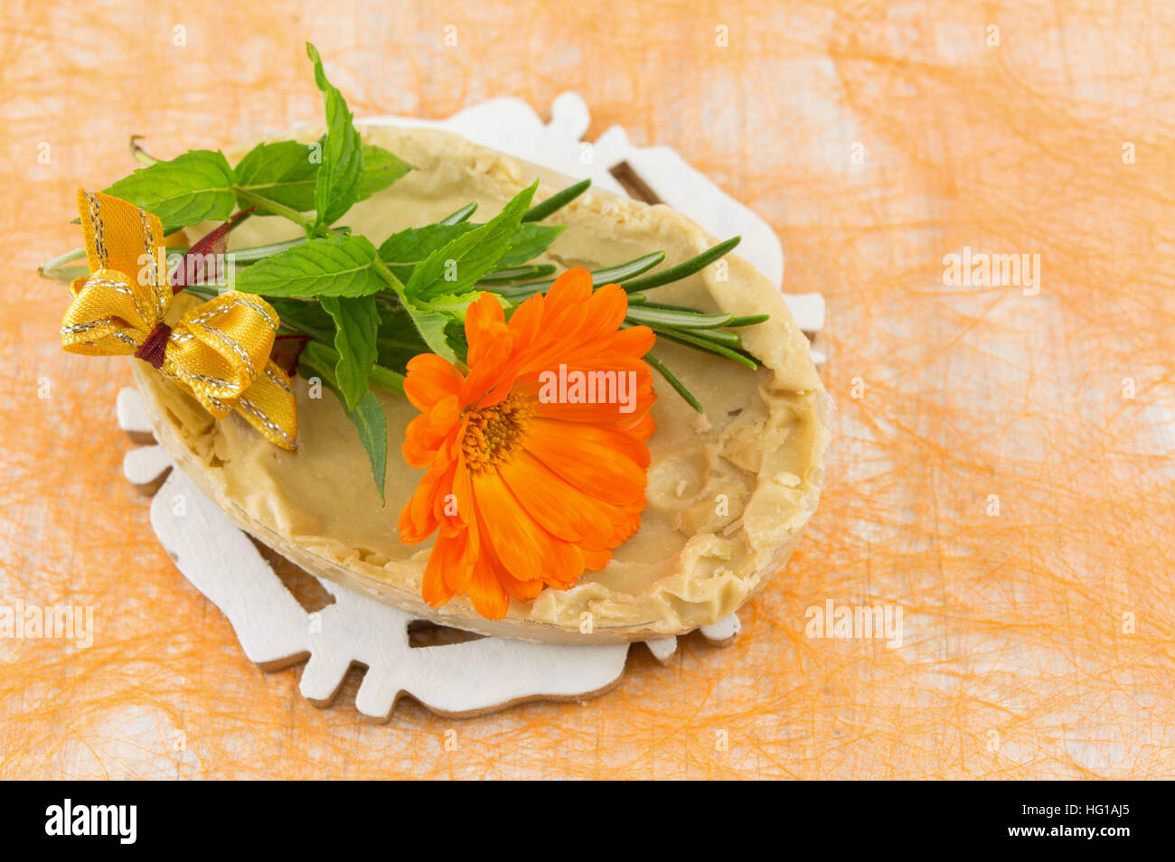 Kräuterseife und eine orange Ringelblumeblume Stockfoto