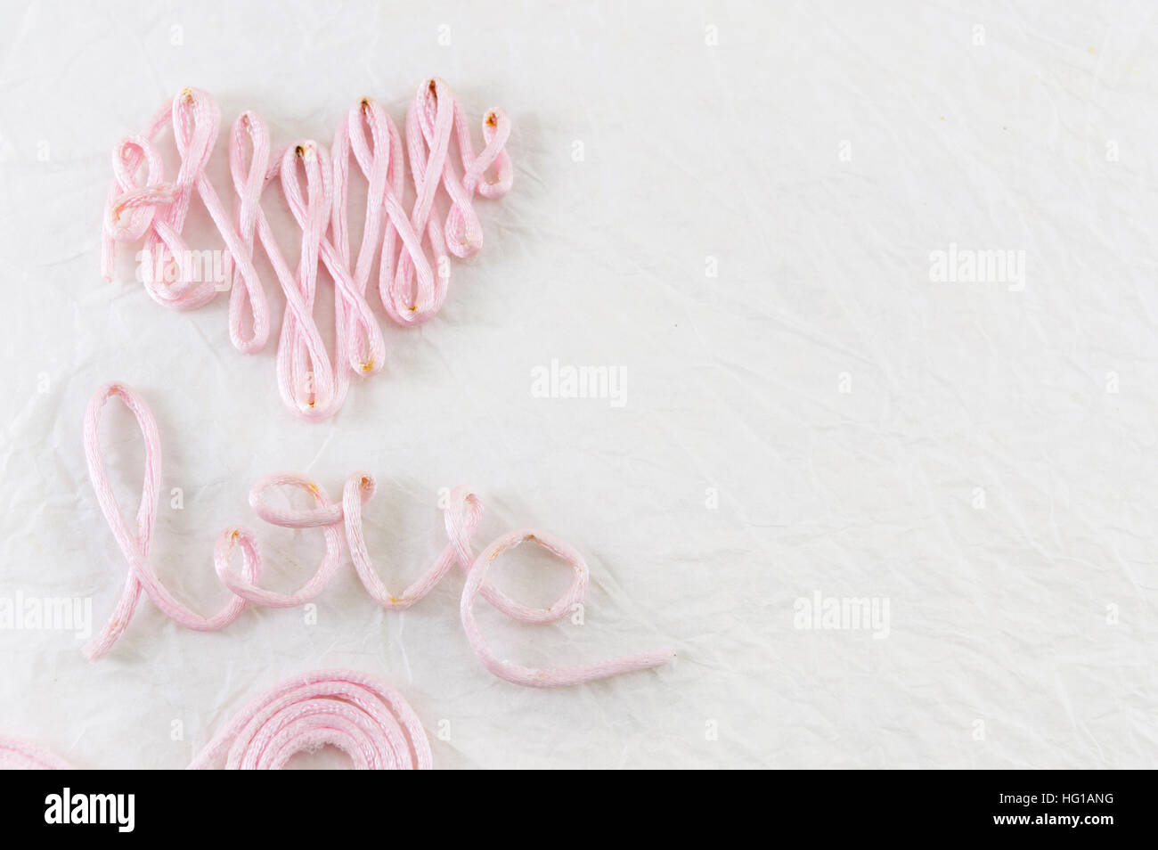 Wort-Liebe gemacht aus rosa Nähgarn Stockfoto