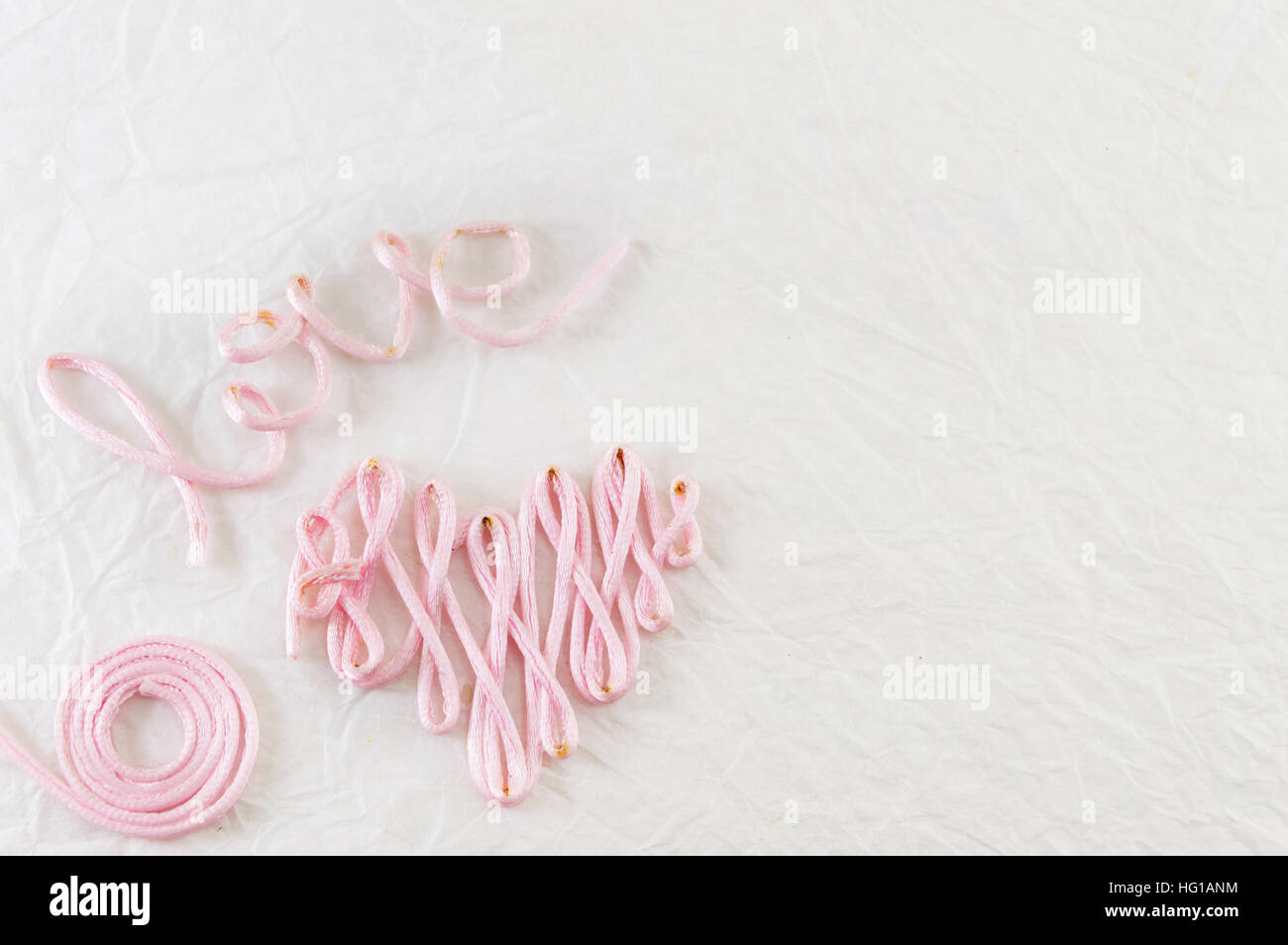 Wort-Liebe gemacht aus rosa Nähgarn Stockfoto