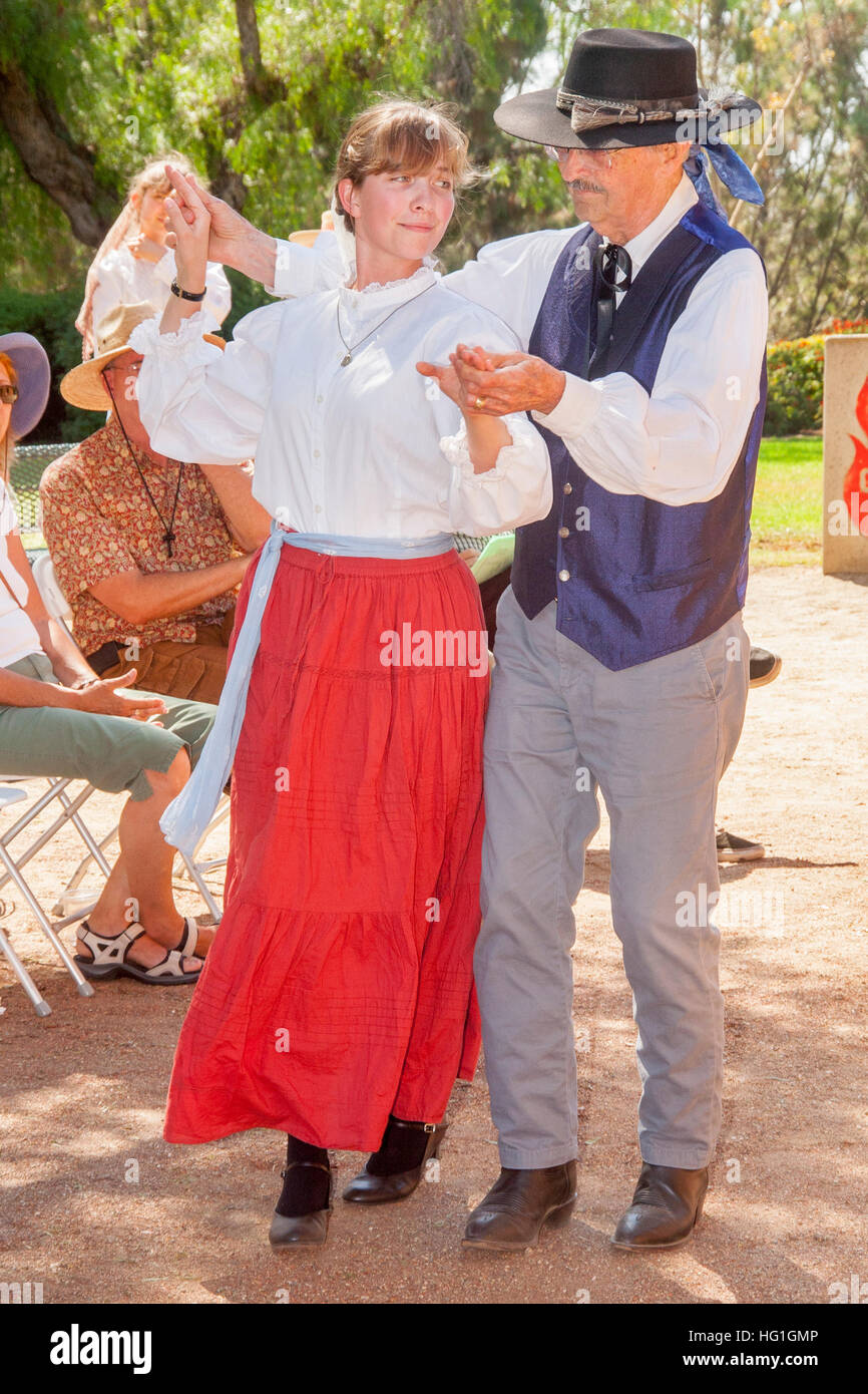 Verkleidet als alte Zeit Spanisch Kalifornier, führen ein Tanzlehrer und Schüler einen historischen spanischen kolonialen Tanz bei einem "Frühen Kalifornien Days"-Festival in einem Park in Costa Mesa, CA. Stockfoto