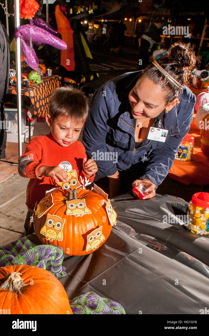 Ein kleiner Junge und seine Mutter Inspect dekoriert Kürbisse auf Ausstellung an einem Halloween Dekoration Wettbewerb in Huntington Beach, Kalifornien. Stockfoto