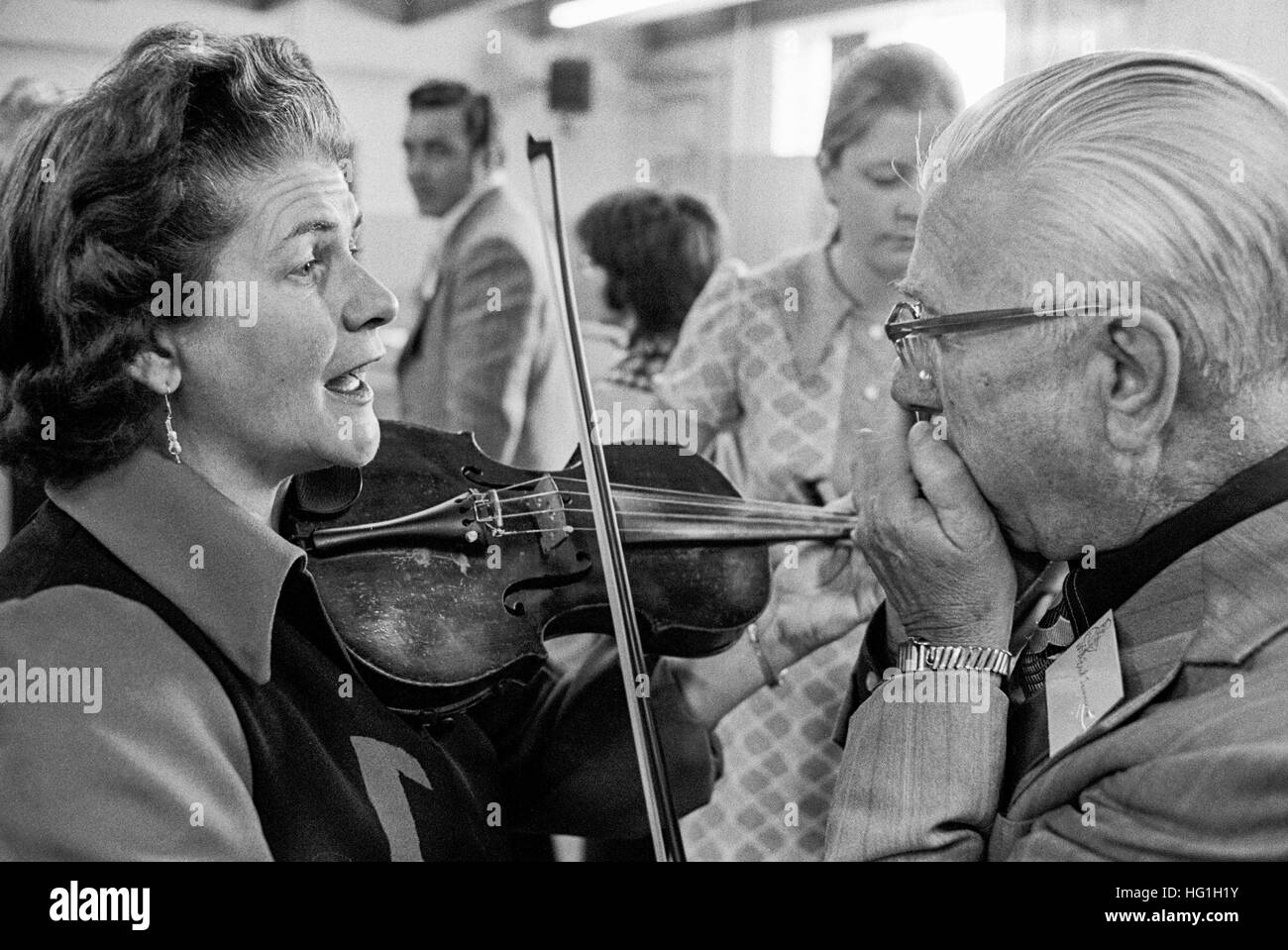 Frau Geiger und einem älteren männlichen Mundharmonika-Spieler Proben hinter den Kulissen bei einem Folk-Musik-Festival und Wettbewerb in Vermont. Stockfoto
