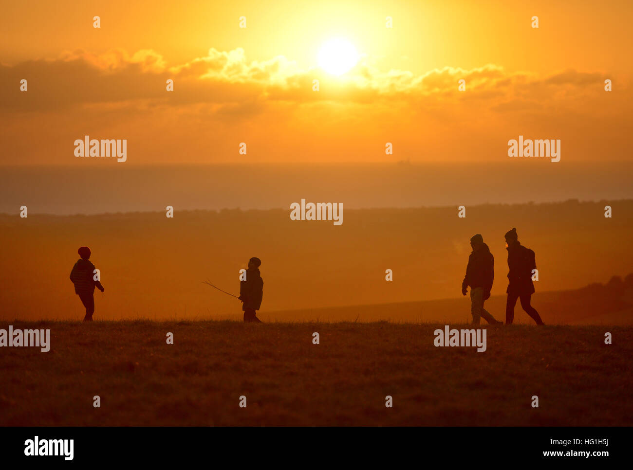 Familie zu Fuß auf den South Downs National Park bei Sonnenuntergang Stockfoto