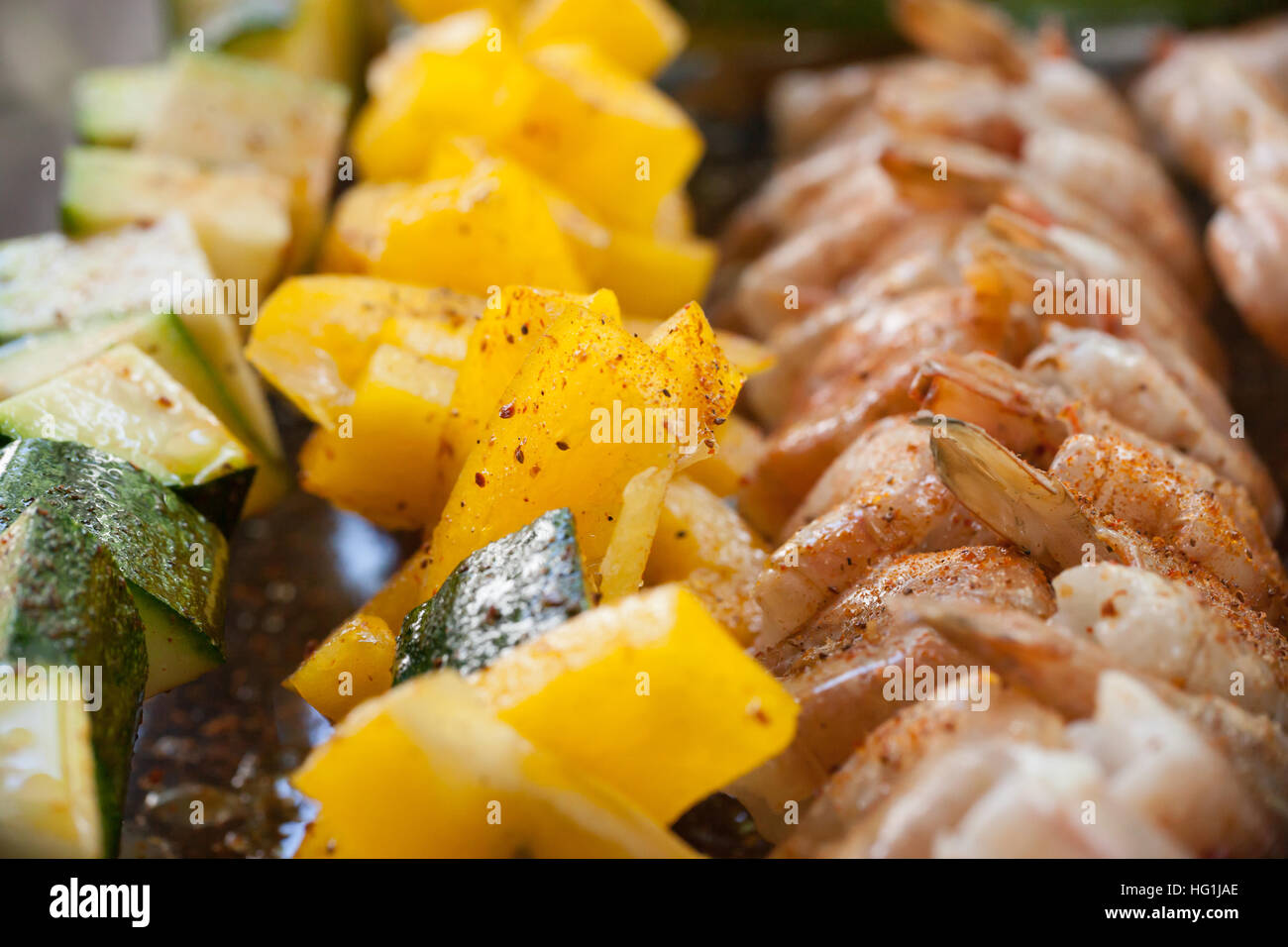 Bunte, Garnelen, Zucchini und orange Paprika, die Kebabs sind roh und fertig gegrillt wird. Stockfoto