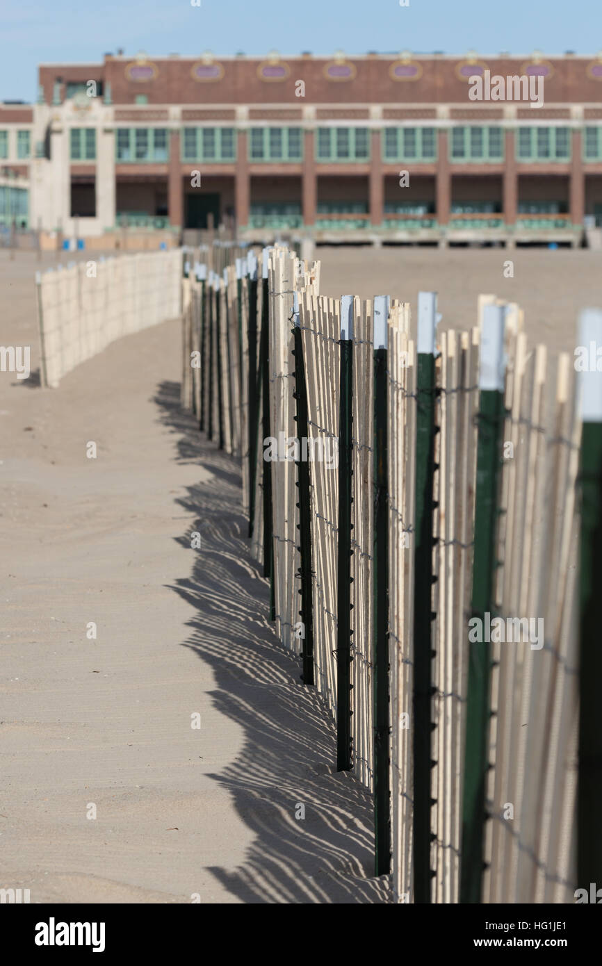 Ein Blick auf einen Zaun Sand am Strand in Asbury Park, New Jersey. Der berühmte Kongresshalle ist im Hintergrund sichtbar. Stockfoto