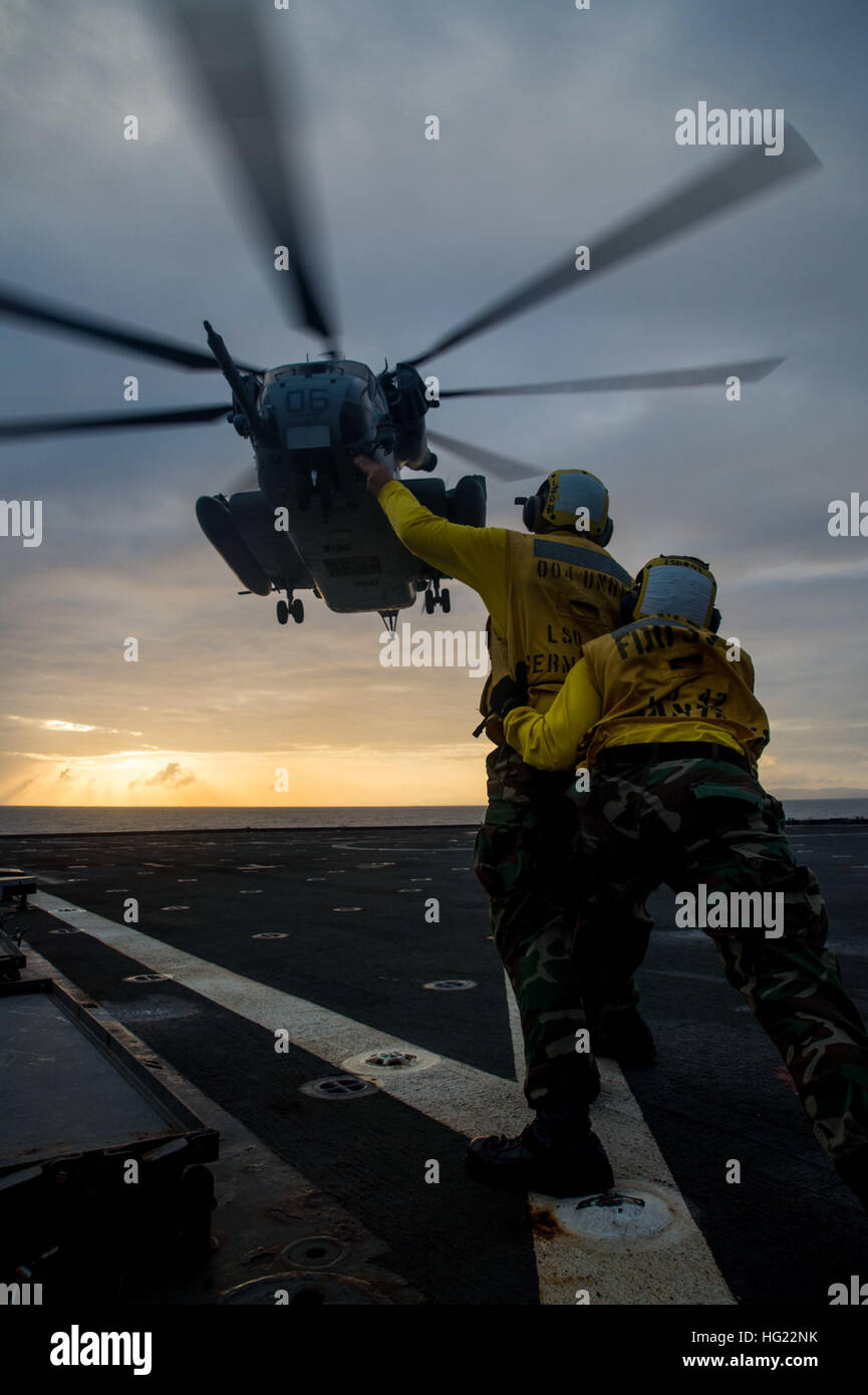 Logistik Spezialist Seemann Maretta Stubbs, nimmt ab von San Antonio (Vordergrund) Hosenträger Bootsmann der 2. Klasse Brian Töpfer, aus Buffalo, New York, als CH-53E Super Stallion-Hubschrauber, zugewiesen, die "Flying Tigers" der Marine schwere Hubschrauber Geschwader (HMH) 361, Paaren aus dem Flugdeck der amphibischen Dock Landungsschiff USS Germantown (LSD 42) während des Trainings blau Chromit. Blaue Chromit ist eine amphibische Übung mit der 4. Marine-Regiment und das 2. Bataillon, 9. Marines. Germantown ist Teil von der Peleliu amphibische bereit Gruppe (#PELARG14), unter dem Kommando von Captain Heidi Agle, eine Stockfoto